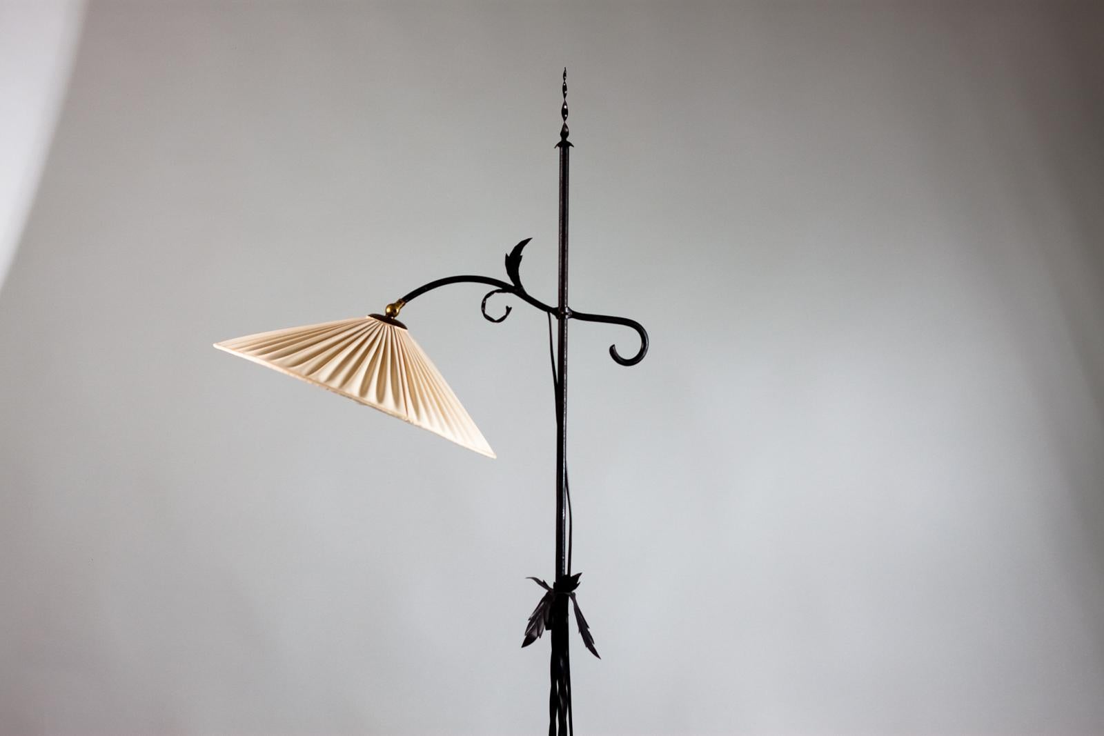 Beautiful wrought iron floor lamp by Antti Hakkarainen for Taidetakomo Hakkarainen in the 1930s, Finland. The floor lamp can be adjusted in hight. 
The beauty is in the details of the lamp. The lamp has an original shade made of fabric.
