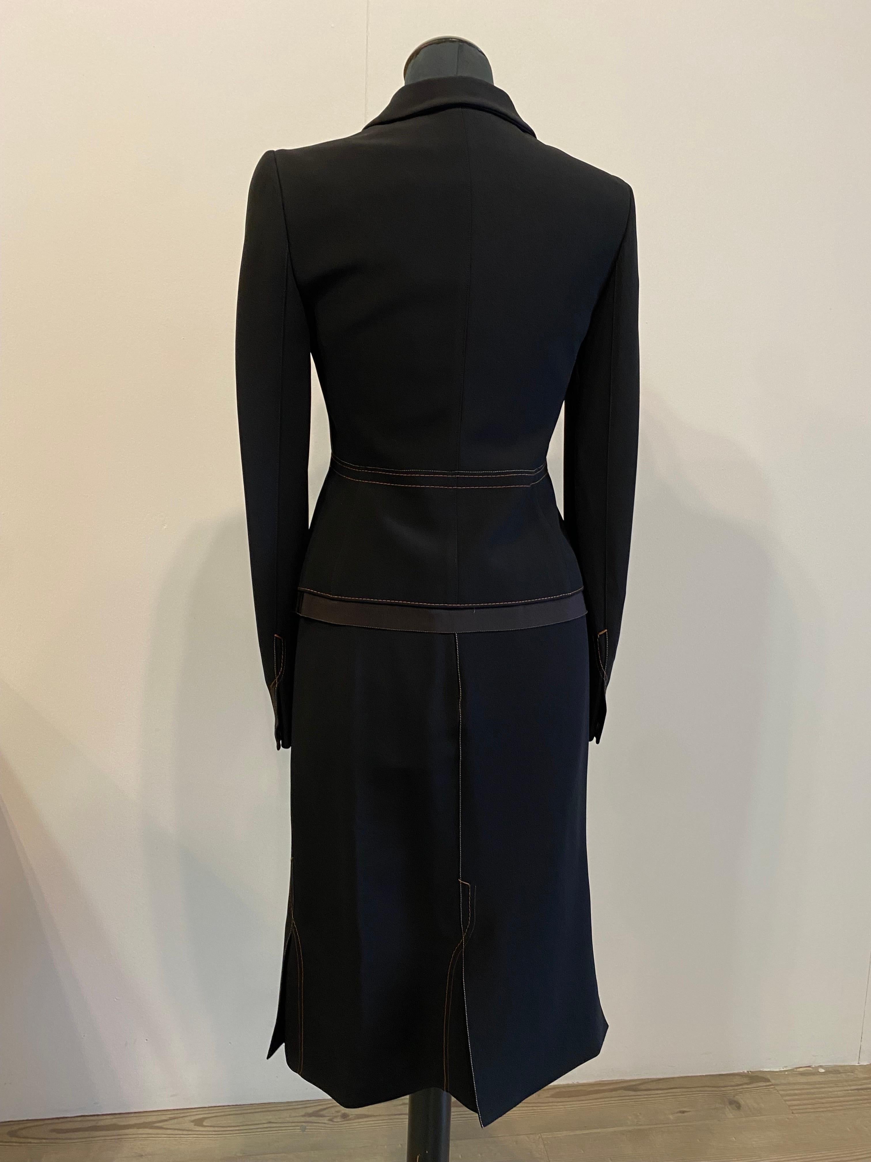 Prada black suit jacket and skirt
In acetate viscose and cotton.
Exposed brown toned stitching
Italian size 42.
The jacket has a hidden bootie closure, except the last one is visible.
Brown ribbed edge on the bottom.
measurement: shoulders 38
Breast