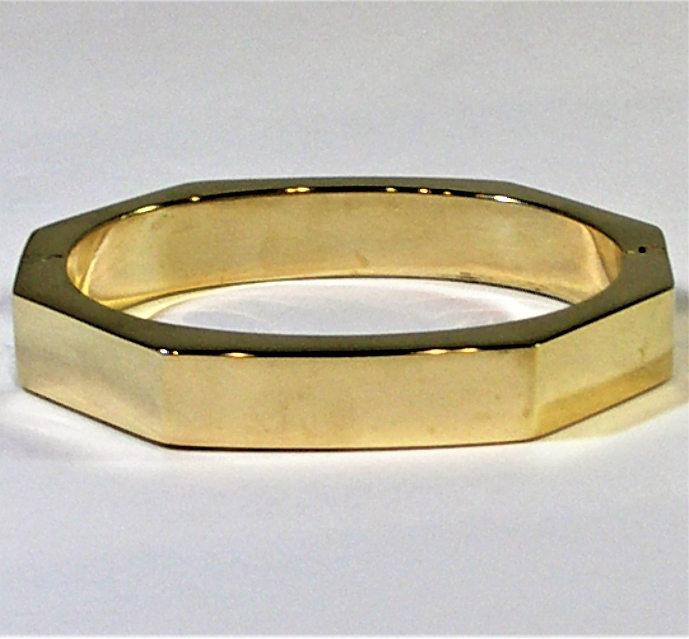 This tailored, 18K Yellow gold, octagonal shaped bangle is beautifully finished both outside and inside. The interior is oval shaped, so that it sits nicely on the wrist, 
without rolling over. Hinged on one side. Fits a small to medium size wrist.