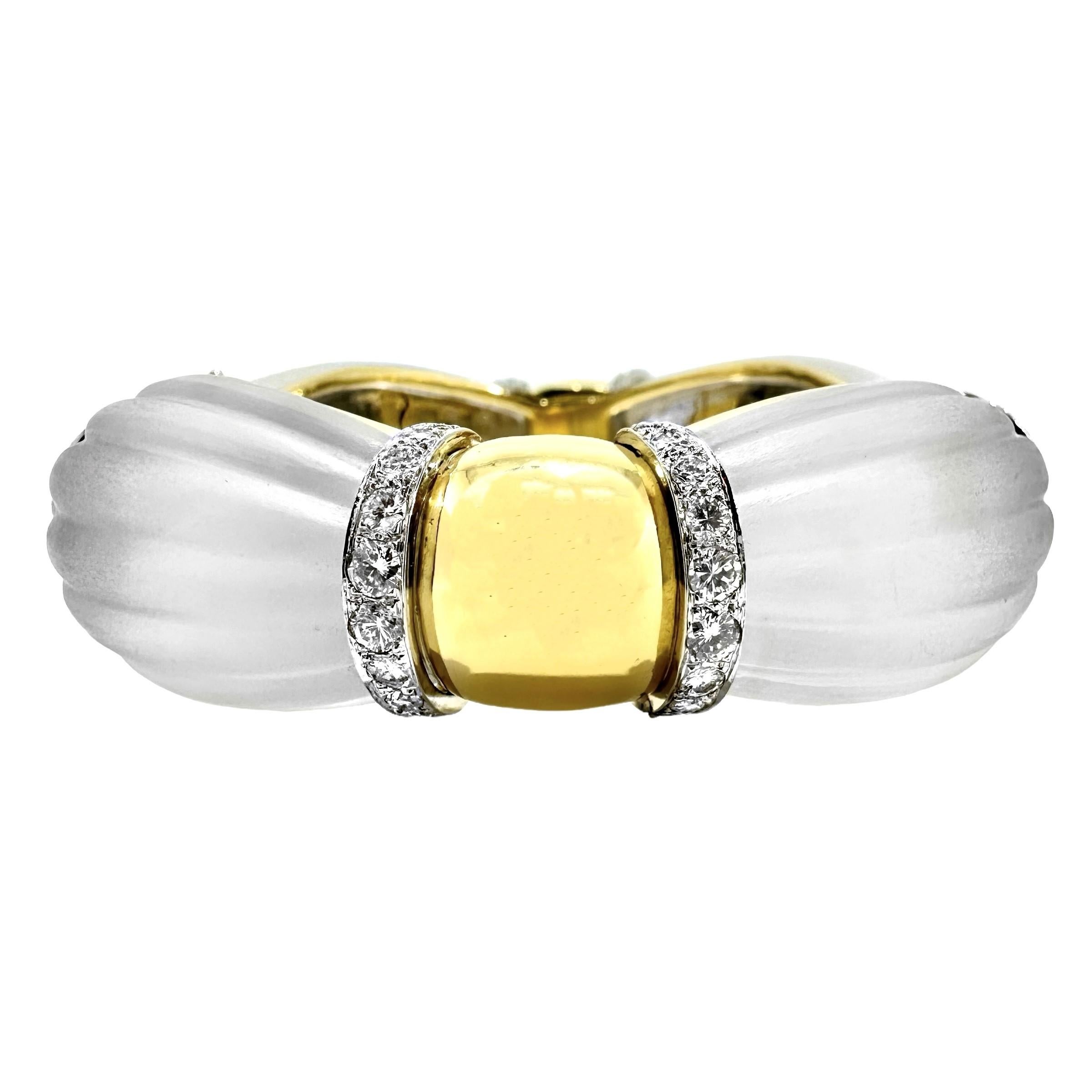 This splendid and very substantial hinged bangle bracelet is a wonderful example of Mid-20th century style and quality workmanship. Four large and dramatic frosted and fluted rock crystal cabochon panels are interrupted at four positions with bombe