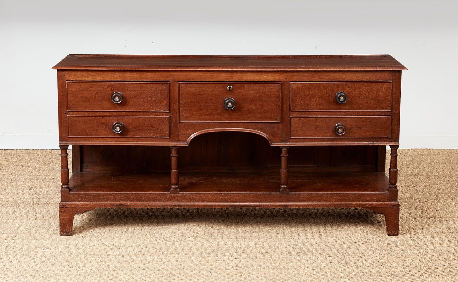 Fine 19th century Welsh dresser, the base with thumb molded top over five drawers all retaining original round ebonized pulls, the lower section with arch over turned canon barrel supports on lower undershelf also known as a pot-board shelf,