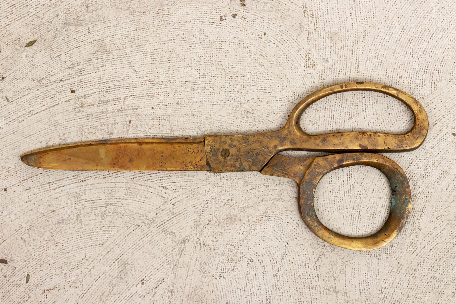 Circa late 19th to early 20th century Tailor's brass trade sign in the shape of scissors. The piece measures 26.00 inches long. Made in the United States. Please note of wear consistent with age including patina and oxidation.