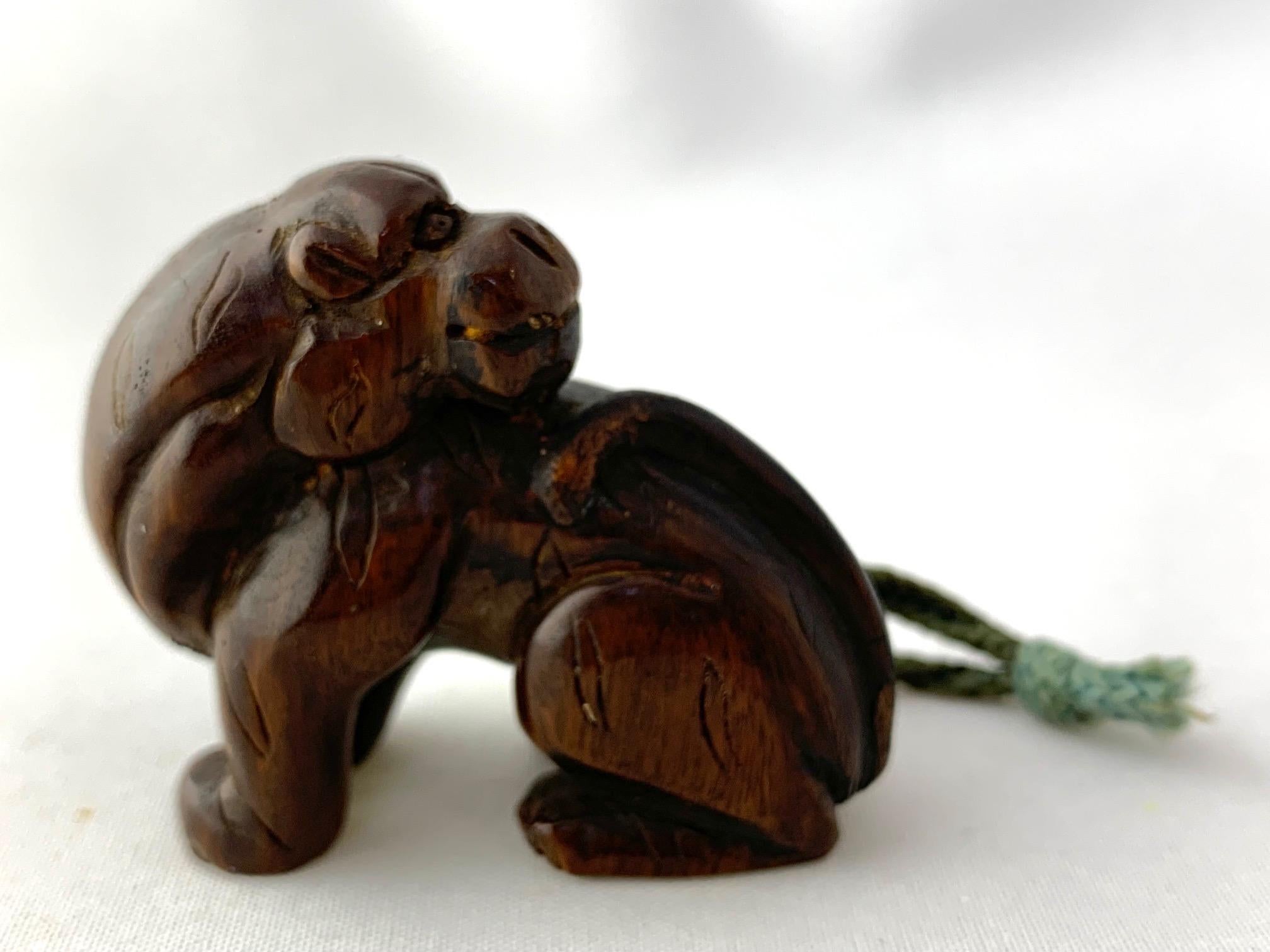 Netsuke del periodo Taisho intagliato a mano che raffigura una tigre con la testa sopra la spalla.   La parola netsuke si forma utilizzando il simbolo ne (根) che significa 