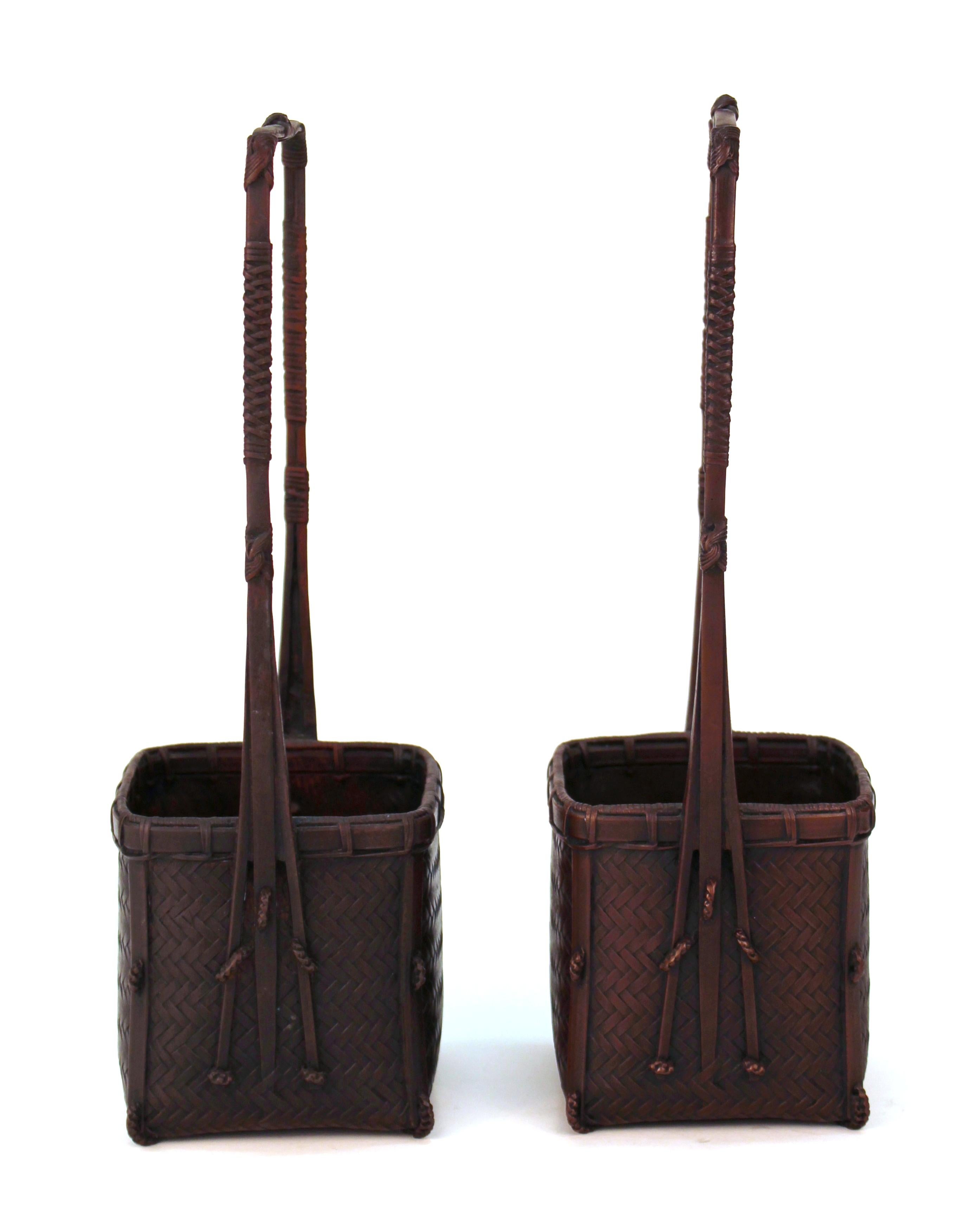Taisho period Japanese pair of ikebana baskets in bronze, with square baskets and tall squared handles. The pair was made in Japan in the 1910s-1920s and has makers marks on the bottom. In great vintage condition with age appropriate patina.