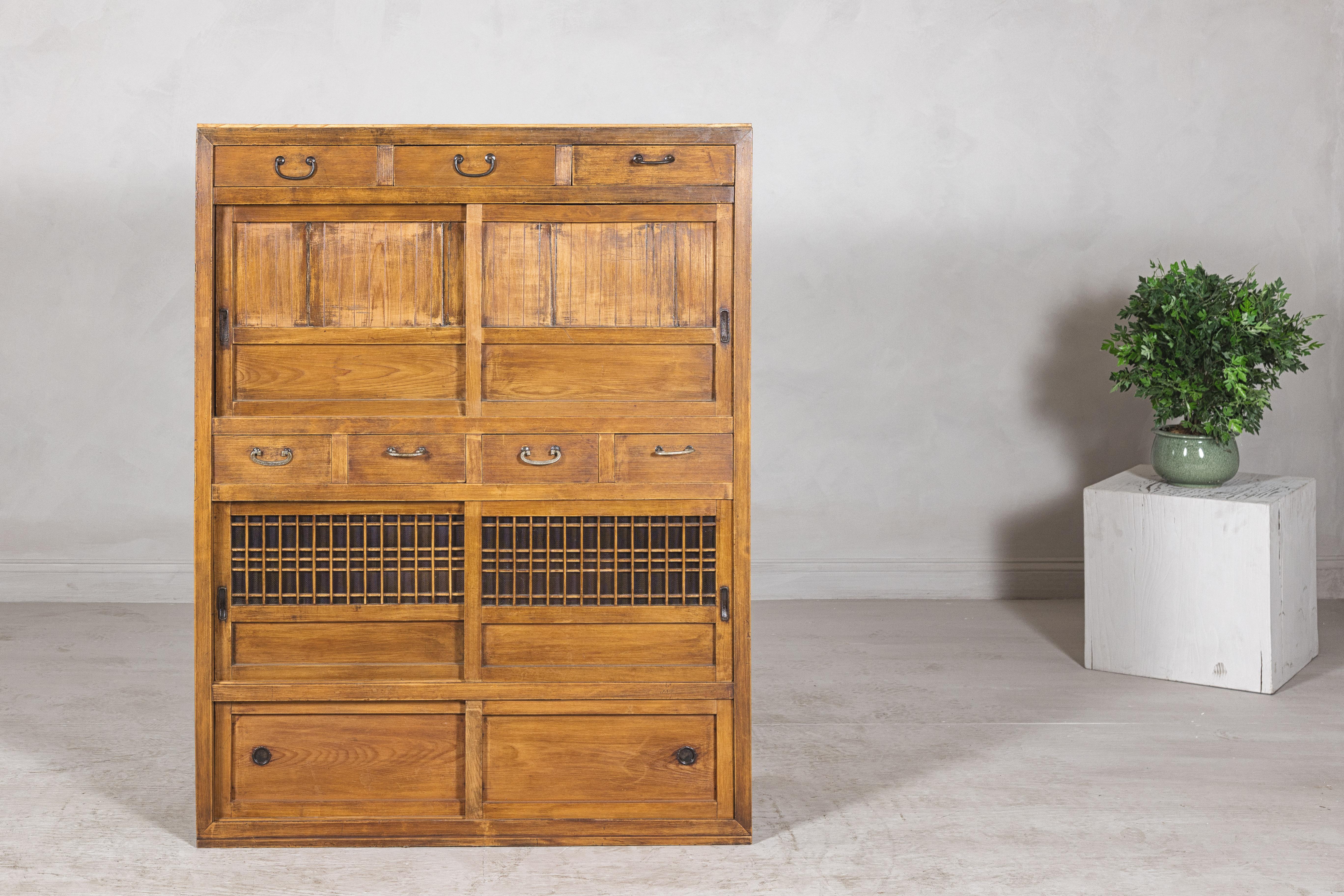 A beautifully constructed Japanese kitchen cabinet, known as a mizuya tansu, from the Taishō period, early 20th century. This tall and versatile chest is crafted in solid sugi (cedar) with a warm golden finish that brings out the richness of the