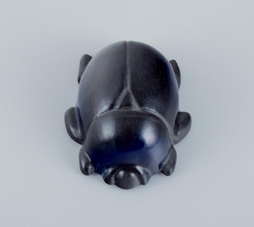 Taisto Kaasinen (1918–1980) for Arabia, Finland. 
Rare ceramic scarab with glaze in blue and black shades.
From the 1970s/1980s.
Marked.
In perfect condition.
Dimensions: Length 11.8 cm x Diameter 9.2 cm.