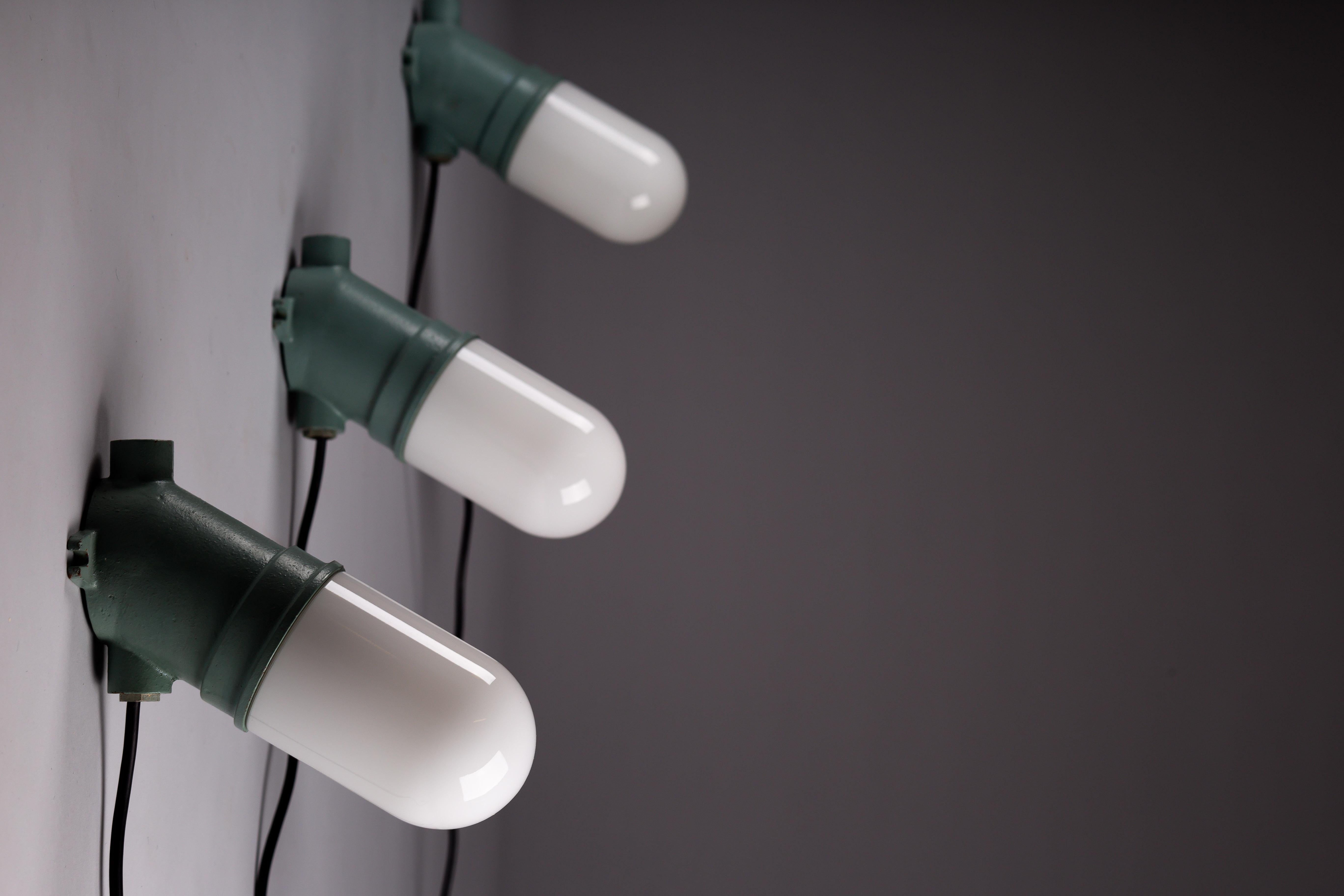 Introducing the exquisite Taito Oy, 1930's industrial cast iron wall lamps with opaline glass lamp shades. Embrace the timeless Scandinavian Vintage Design with these meticulously crafted fixtures that effortlessly blend sturdy industrial aesthetics
