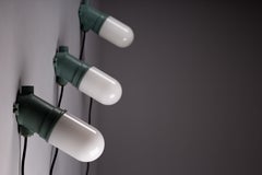 Taito Oy, set of three green 1930's cast iron industrial wall lamps