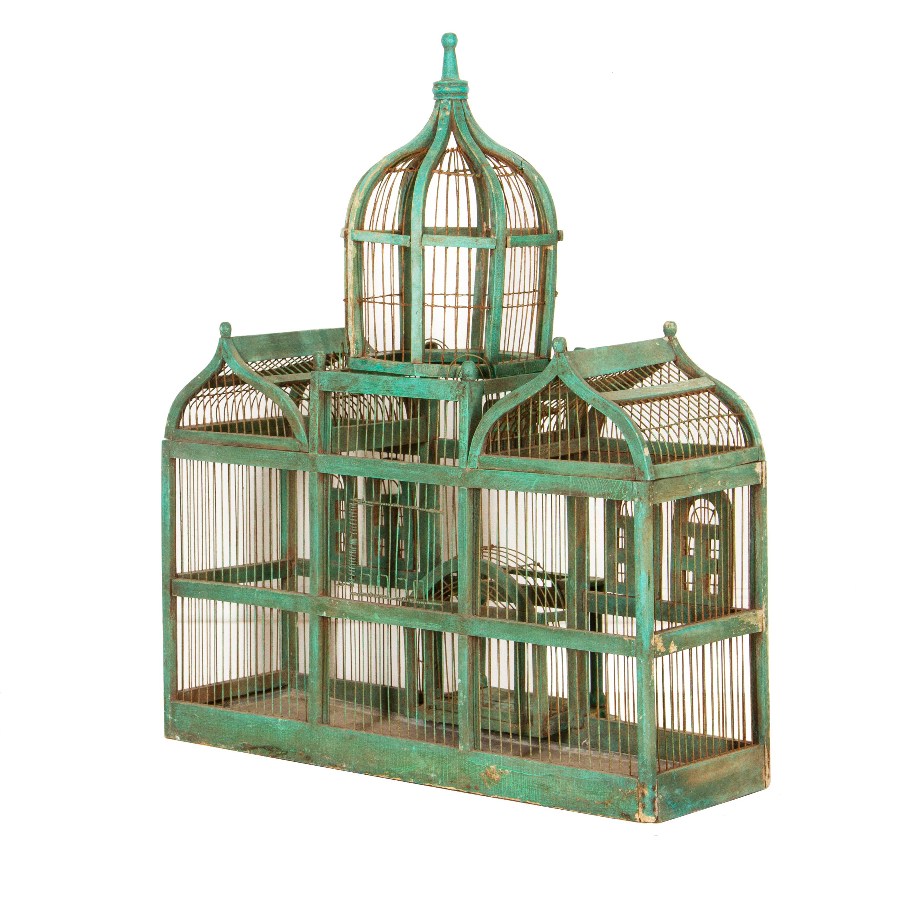 Charming Victorian birdcage in the style of the Taj Mahal. This birdcage has been constructed from painted wood and wire. It has three domes to the top, a working porch door, and another door to the back. At the very bottom of this birdcage is its