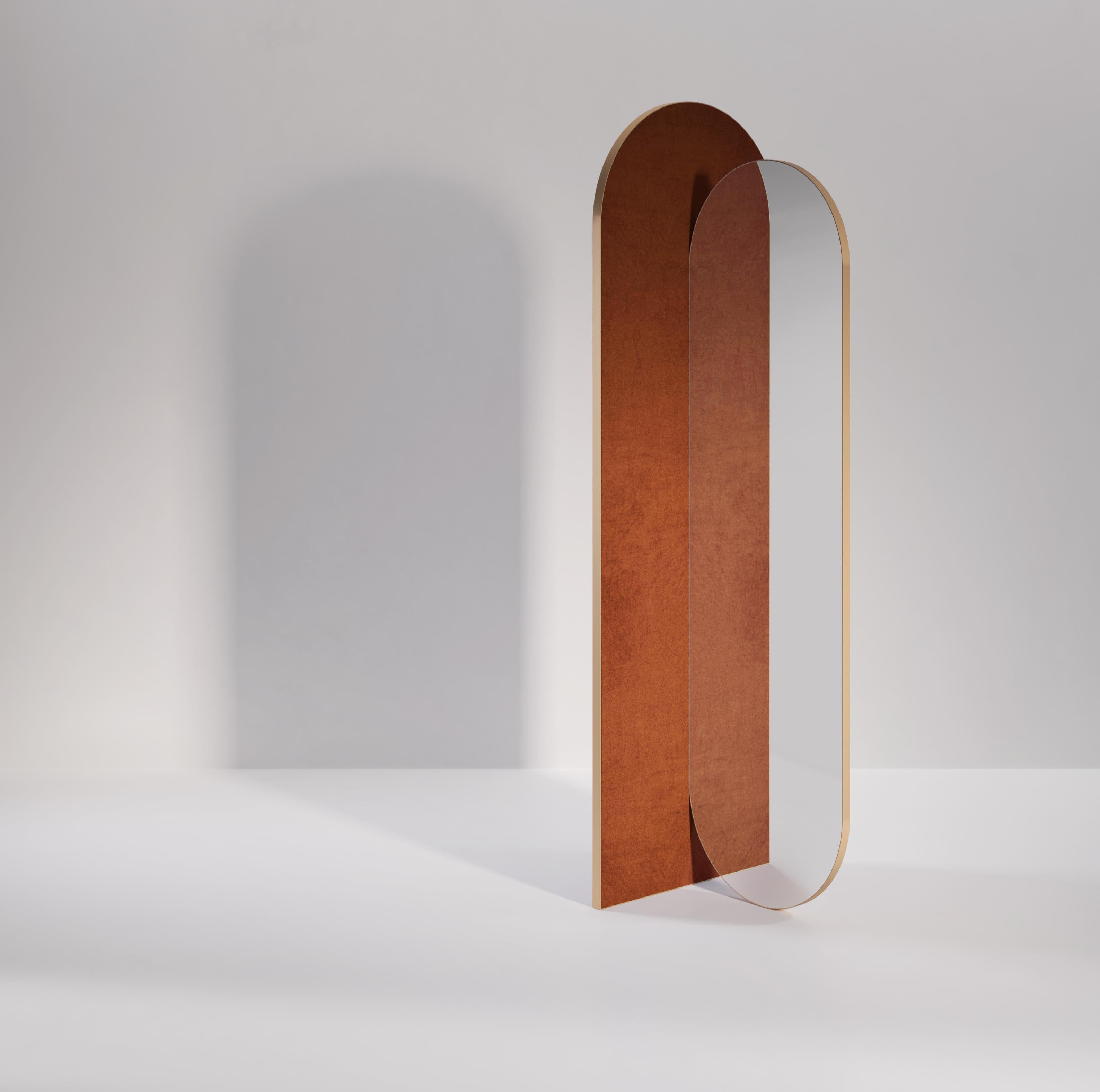 The Takada mirror is a round top and bottomed mirror, made stable only by its connection to a separate, supporting arch. Both the mirror and arch are wrapped in a metal band which can be brass or any other metal finish. The back of the mirror and