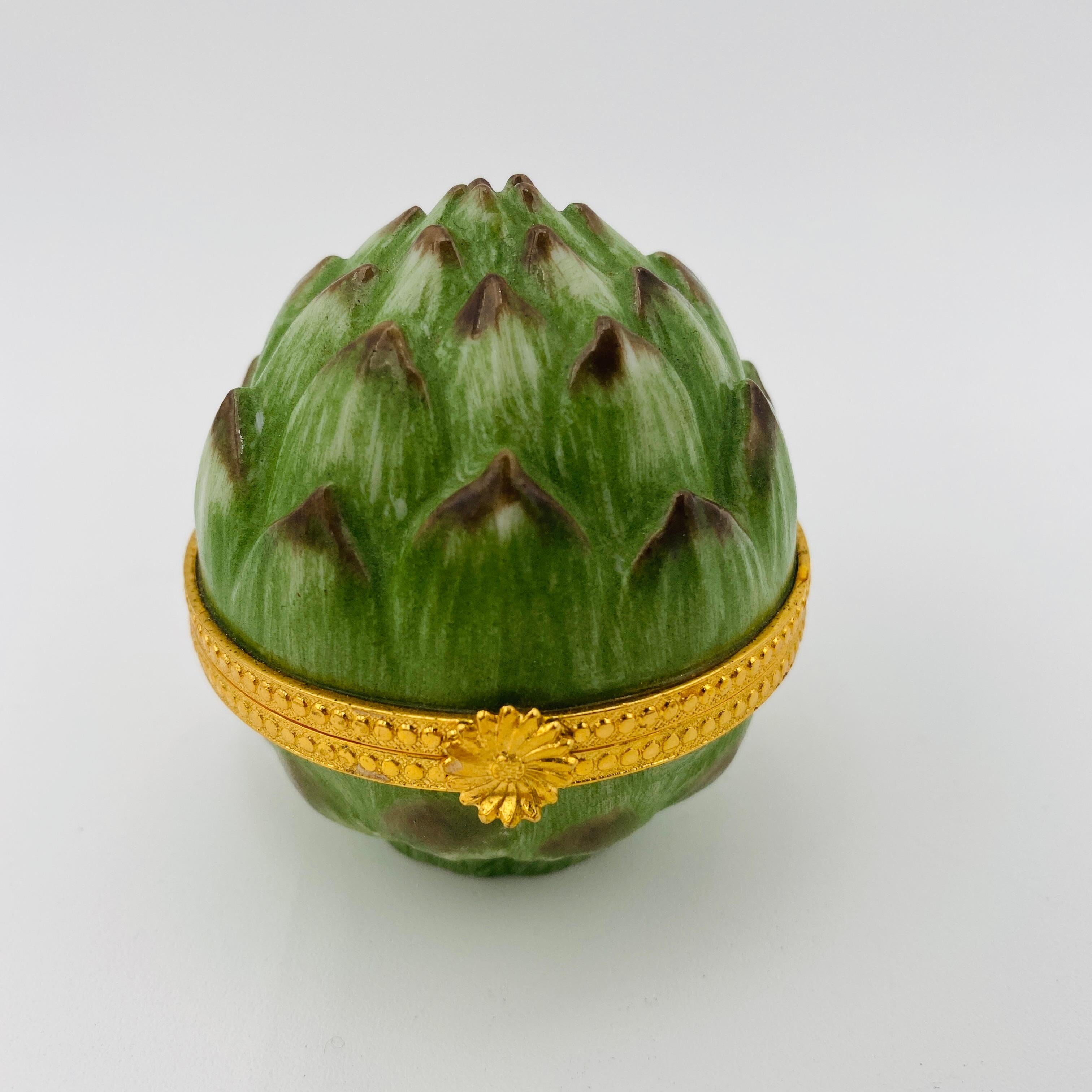Una hermosa y pequeña caja de alcachofas de porcelana de Takahashi, fabricada en Japón en el siglo XX. Se trata de una divertida caja verde de alcachofas para frutas y verduras con bisagra de latón dorado y elevación frontal en forma de flor. Es a