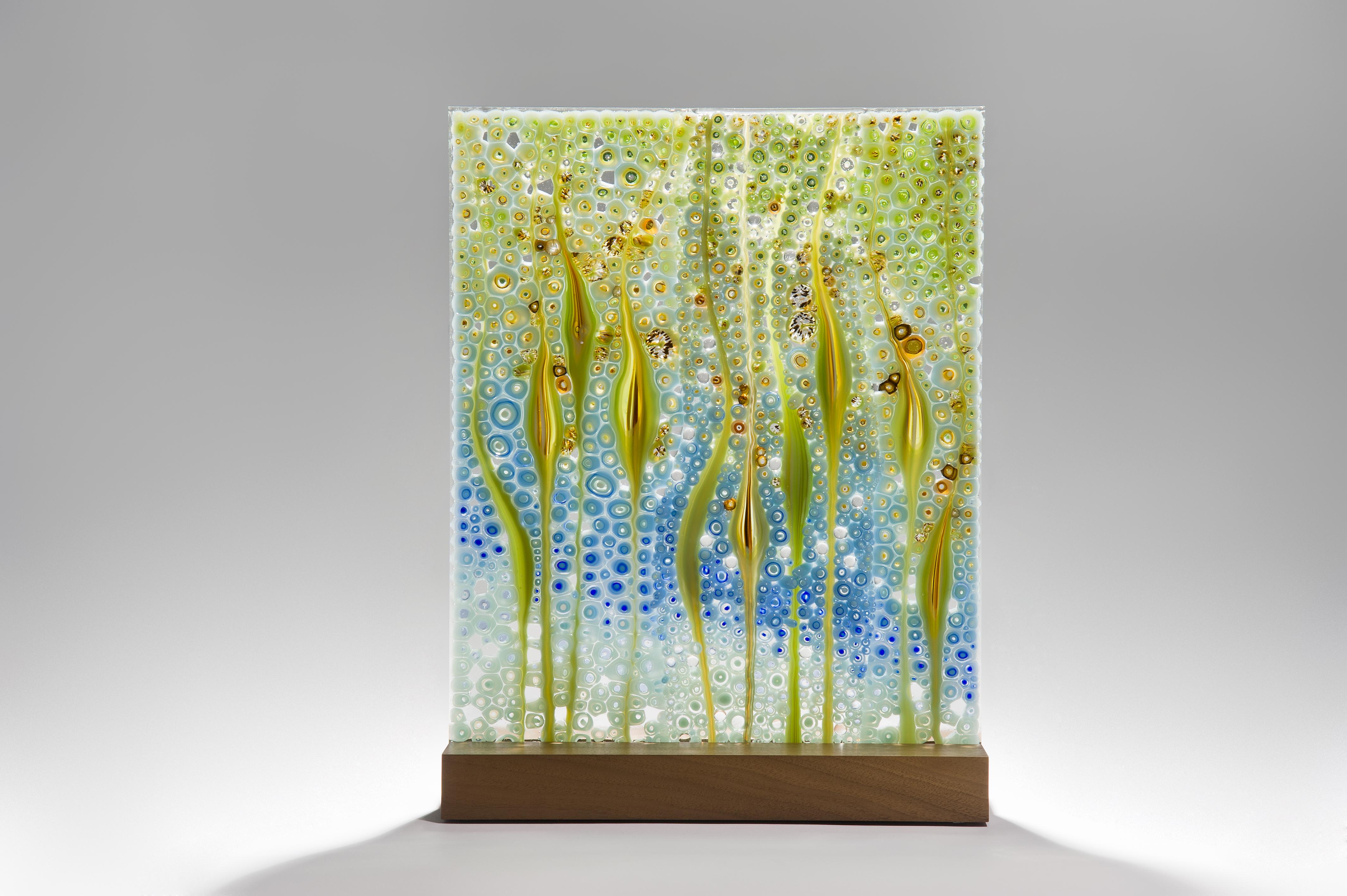 The depth shown is for the walnut wood base.

Takamaka coconut beach, is a unique green and blue glass sculpture by the Austrian artist Sandra A. Fuchs. Fuchs creates her own multicolored and complex glass canes, which are then cut to create small