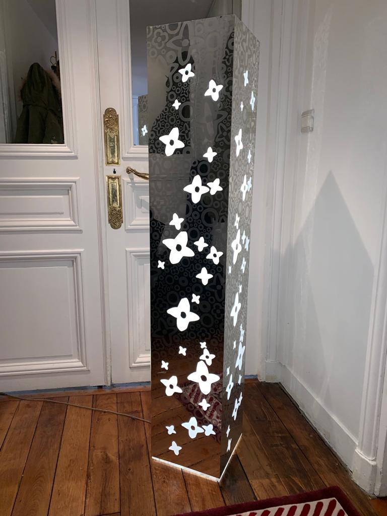 Very rare illuminated pedestal designed by Takashi Murakami for the Louis Vuitton house. This furniture allowed to expose the bags in the Louis Vuitton Champs Elysées store in 2014.
It is decorated with Takashi flowers and LV monogram on 4