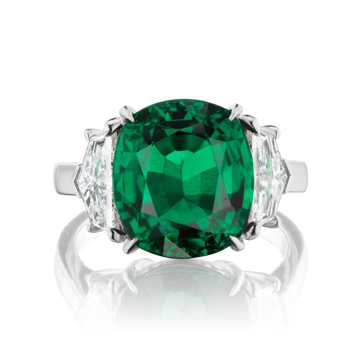 A simply stunning and substantial GRS Certified Zambian Emerald is the star of this classic platinum ring. The 7.28ct vibrant green Emerald is embraced on either side by a high quality shield cut diamond 0.54cts each E,F /VVs.
Item:	#