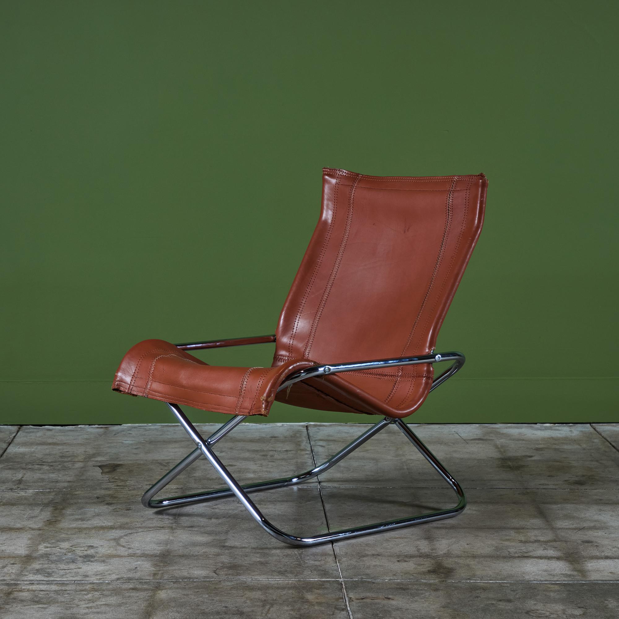 A Japanese modern folding chair, designed by Takeshi Nii, c.1970s. The chair has a chrome frame that folds up like a director’s chair for ease of storage. A patinated leather sling provides the seat which is set on a tubular chrome