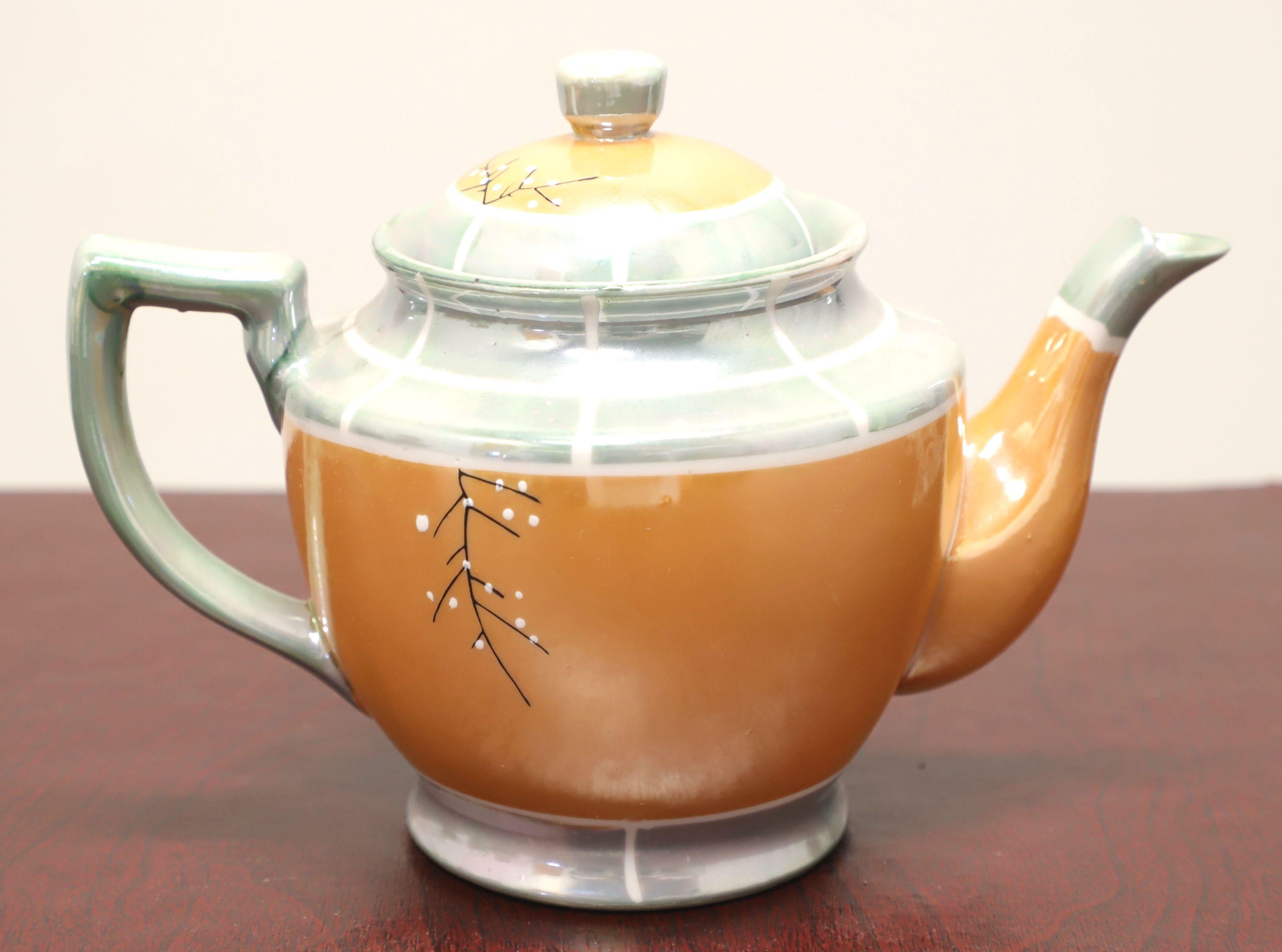Service à thé pour six personnes de style asiatique par Takito, au début du milieu du 20e siècle. Fine porcelaine lustrée, peinte à la main en blanc, pêche et gris/bleu avec des accents noirs et verts d'un motif de fleurs de cerisier, composée de