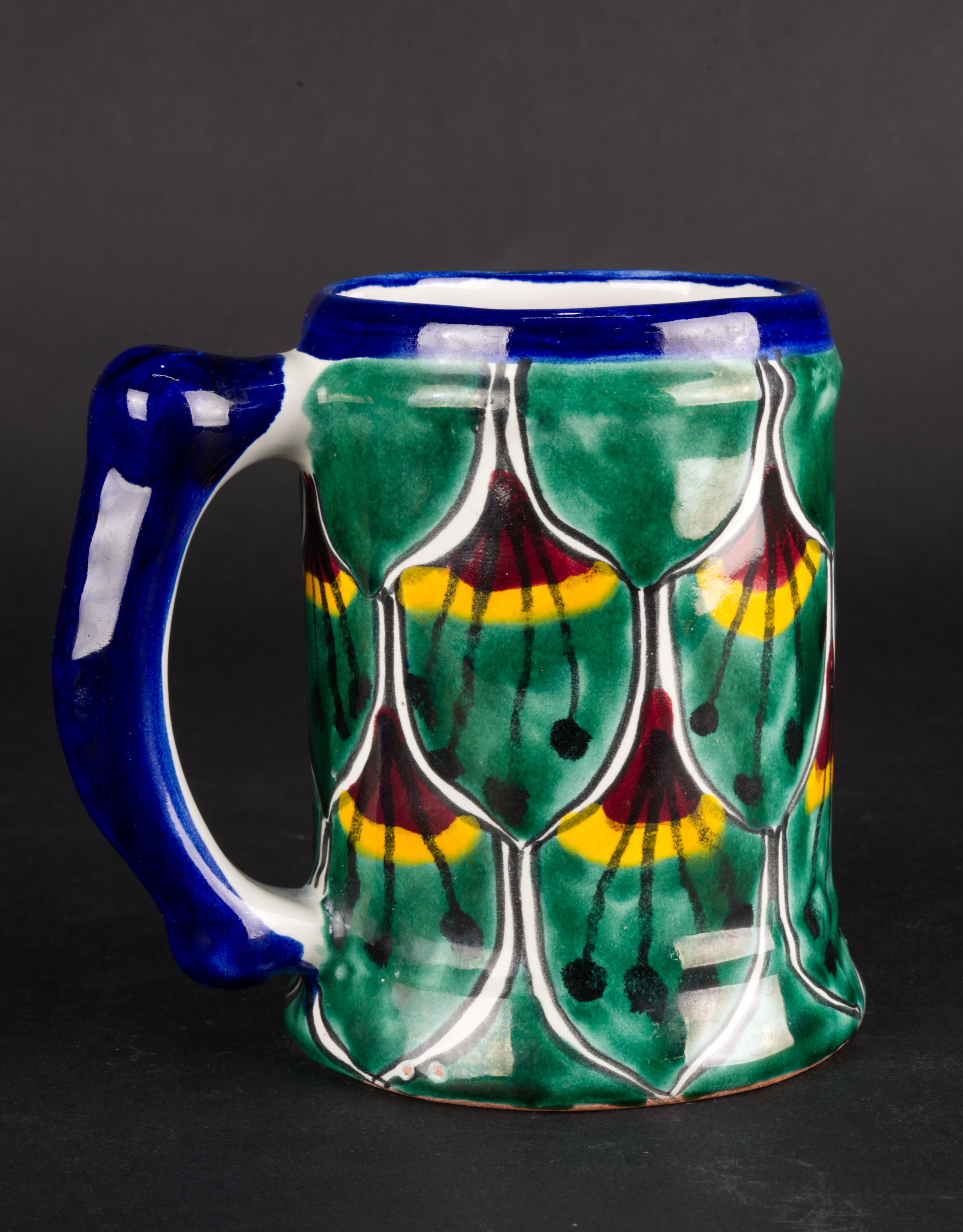 
Vintage oversized mug or stein was handmade by artisans in Talavera, Mexico. The mug is decorated with traditional Peacock design in deep green and blue with dark red and bright orange accents; the handle and rim are accented in solid blue. Inner