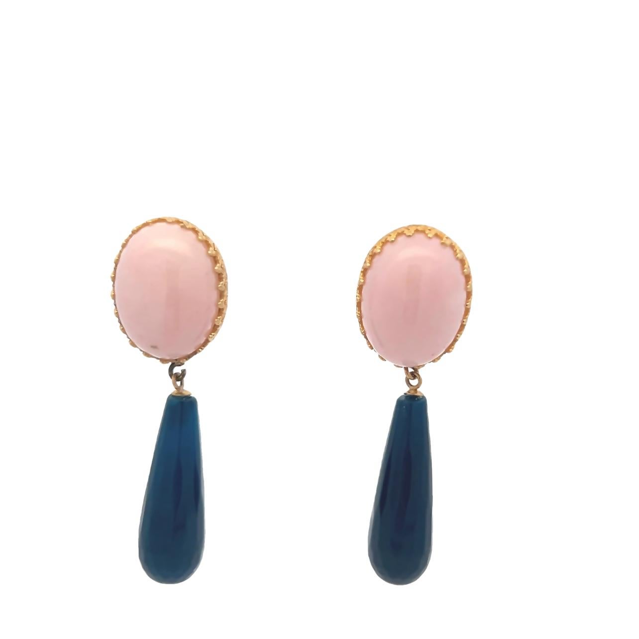 Designed and handcrafted in the USA by Talia Jade, these elegant drop earrings showcase a vibrant interplay of color and form. Set in 14 karat yellow gold, the earrings feature oval cabochons of natural pink coral totaling approximately 20 carats,