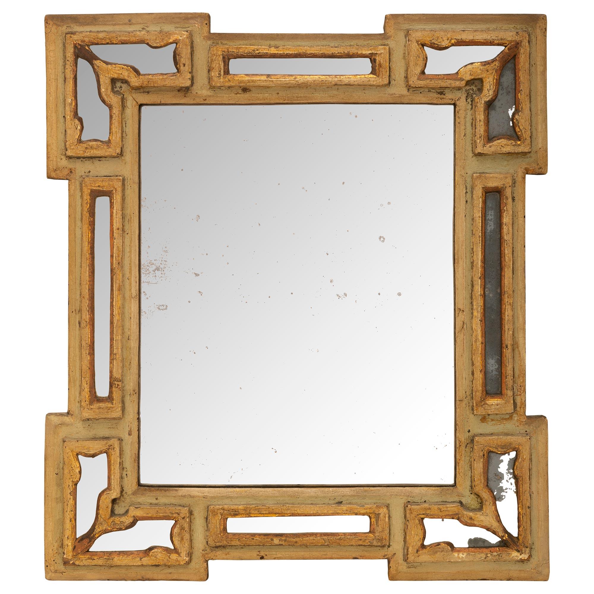 A small scale and charming Italian 18th century Baroque st. double frame patinated wood and gilt mirror. The rectangular mirror with its original patinated off white frame has eight outer gilt panels with fitted mirror plates. All original gilt and