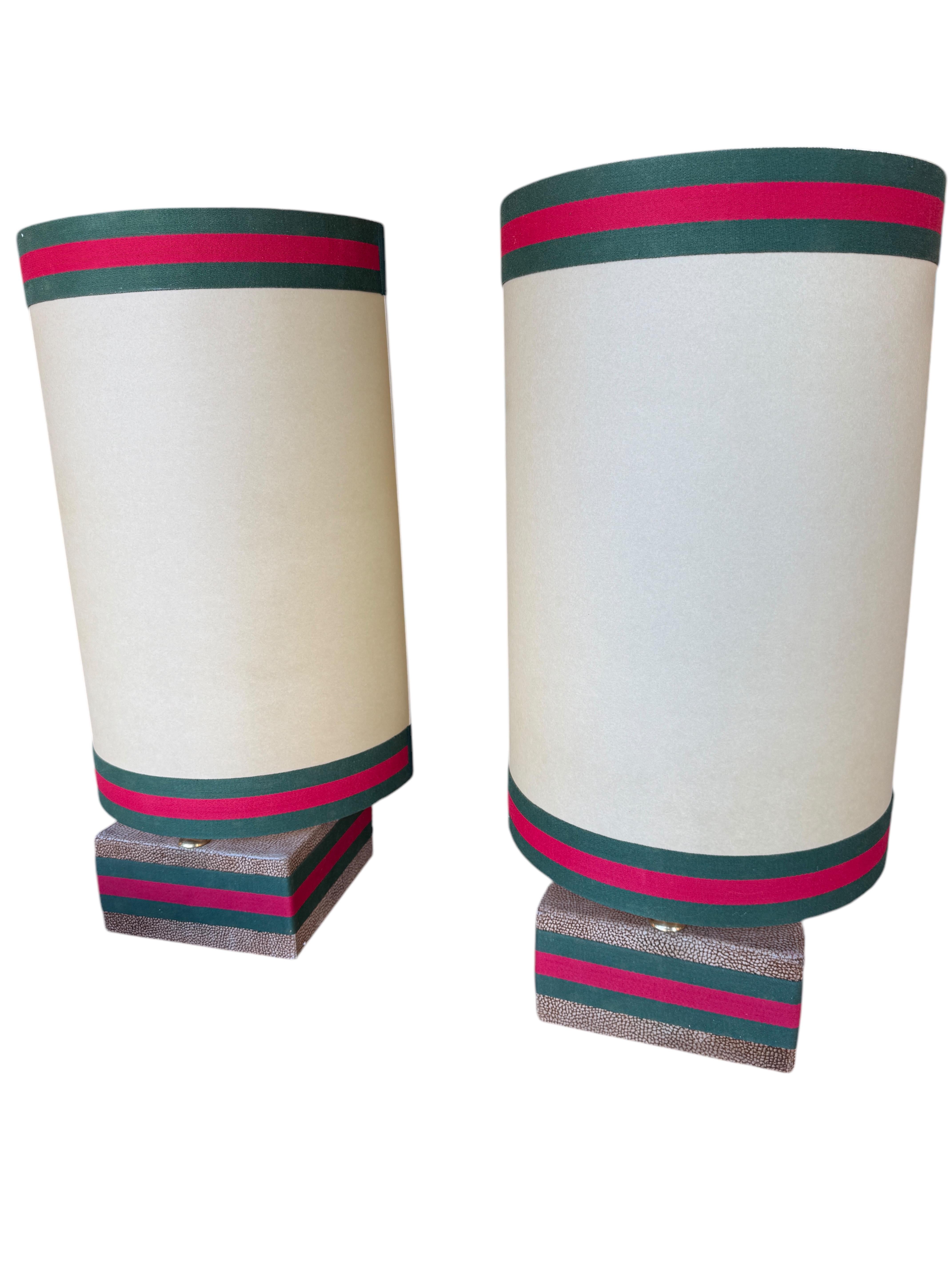 Si tratta di una coppia di suggestive lampade da tavolo della collezione Rossi Di Albizate, disegnate da Carlo Bartoli, noto per i suoi design innovativi e artistici. Le lampade presentano paralumi cilindrici color crema con un elemento di design