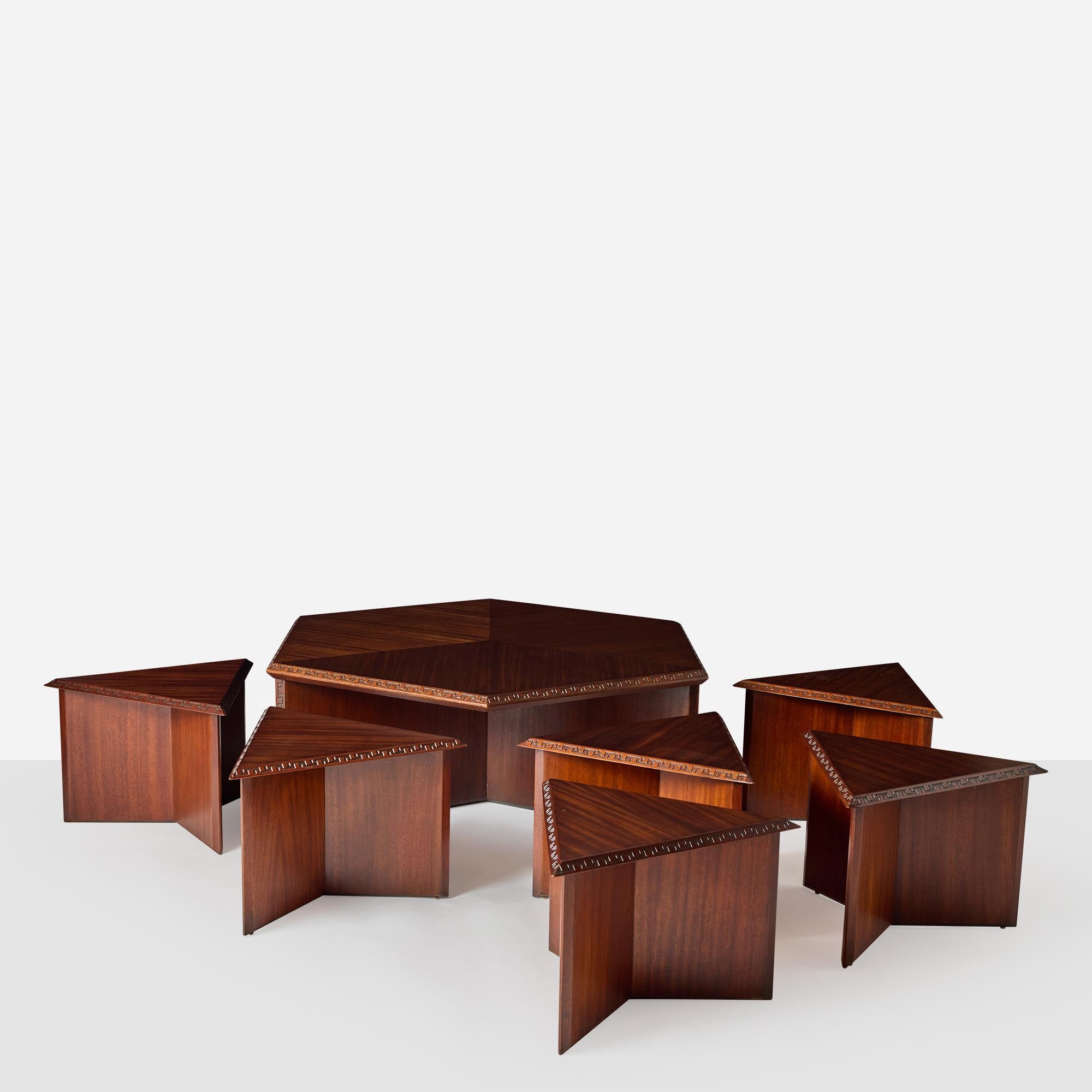 A spacious Taliesin hexagonal cocktail table by Frank Lloyd Wright for Heritage Henredon, featuring six triangular tables that nest perfectly beneath. Each triangle can double as additional seating when paired with small cushions. Fully restored to