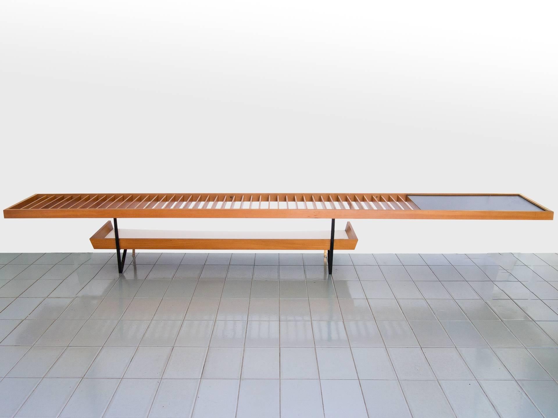 Huge table or bench made of vertical Pau Marfim slats, with magazine holder underneath and a formica top table to the right side. This piece is unique and made to order in 1958. It should be fixed to the walls in the back and on the right side