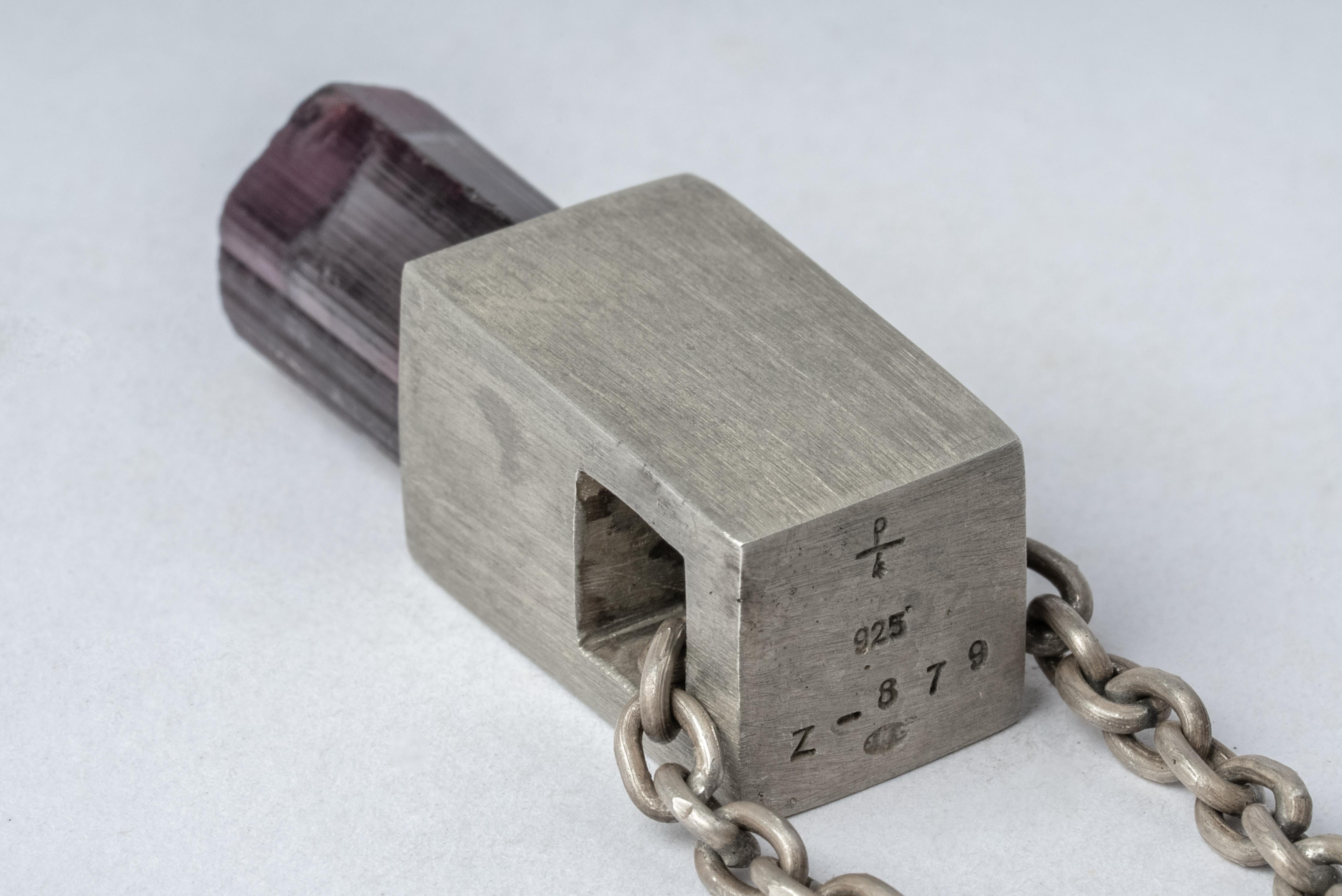 Necklace in the shape of cuboid in acid treated sterling silver and rubellite. The Talisman series is an exploration into the power of natural crystals. The title Specimen signifies a particular class of mineral that is both rare and collectable.