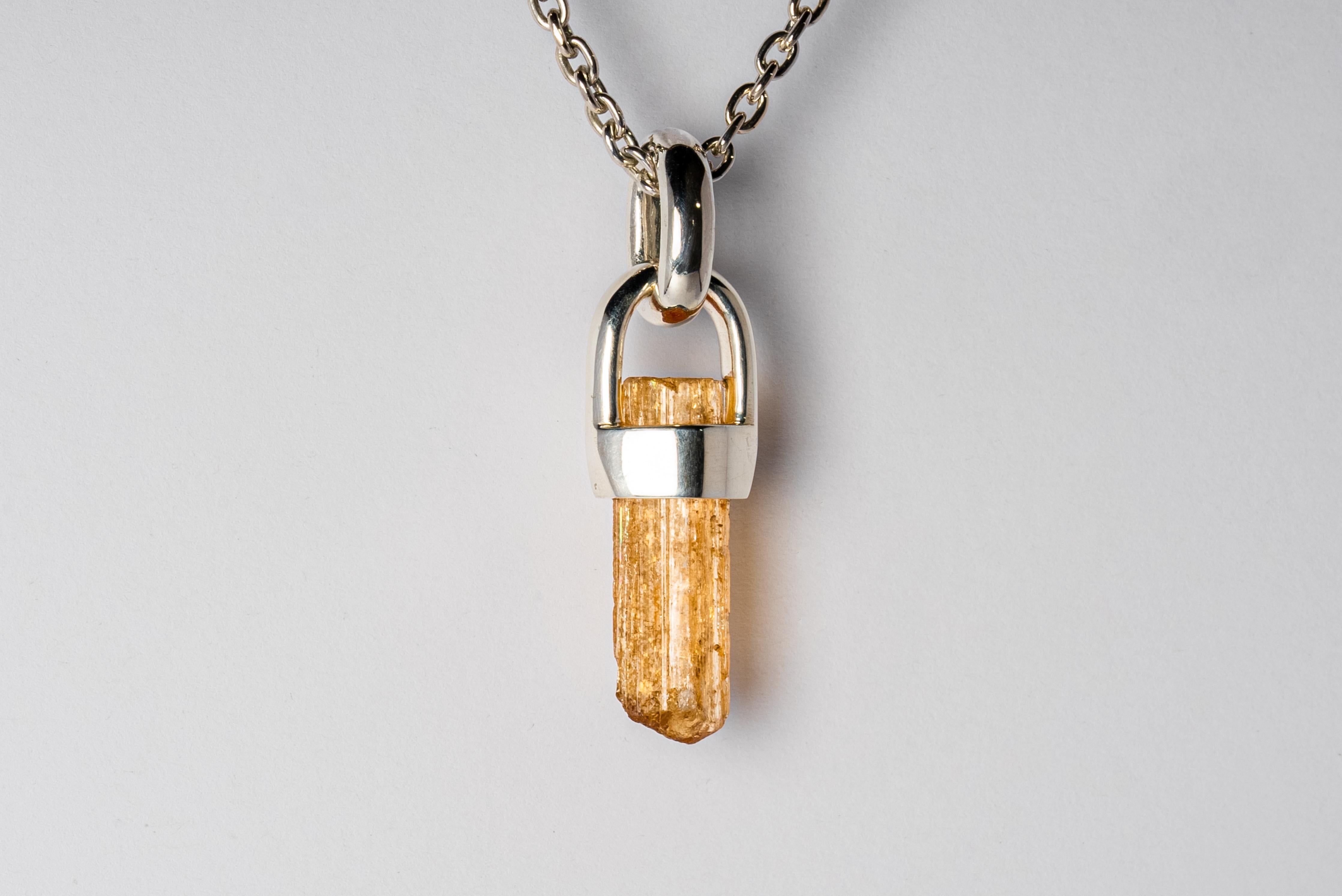 Necklace in polished sterling silver and a rough of imperial topaz on brace-held. The Talisman series is an exploration into the power of natural crystals. The crystals used in these pieces are discovered through adventure and are hand selected.