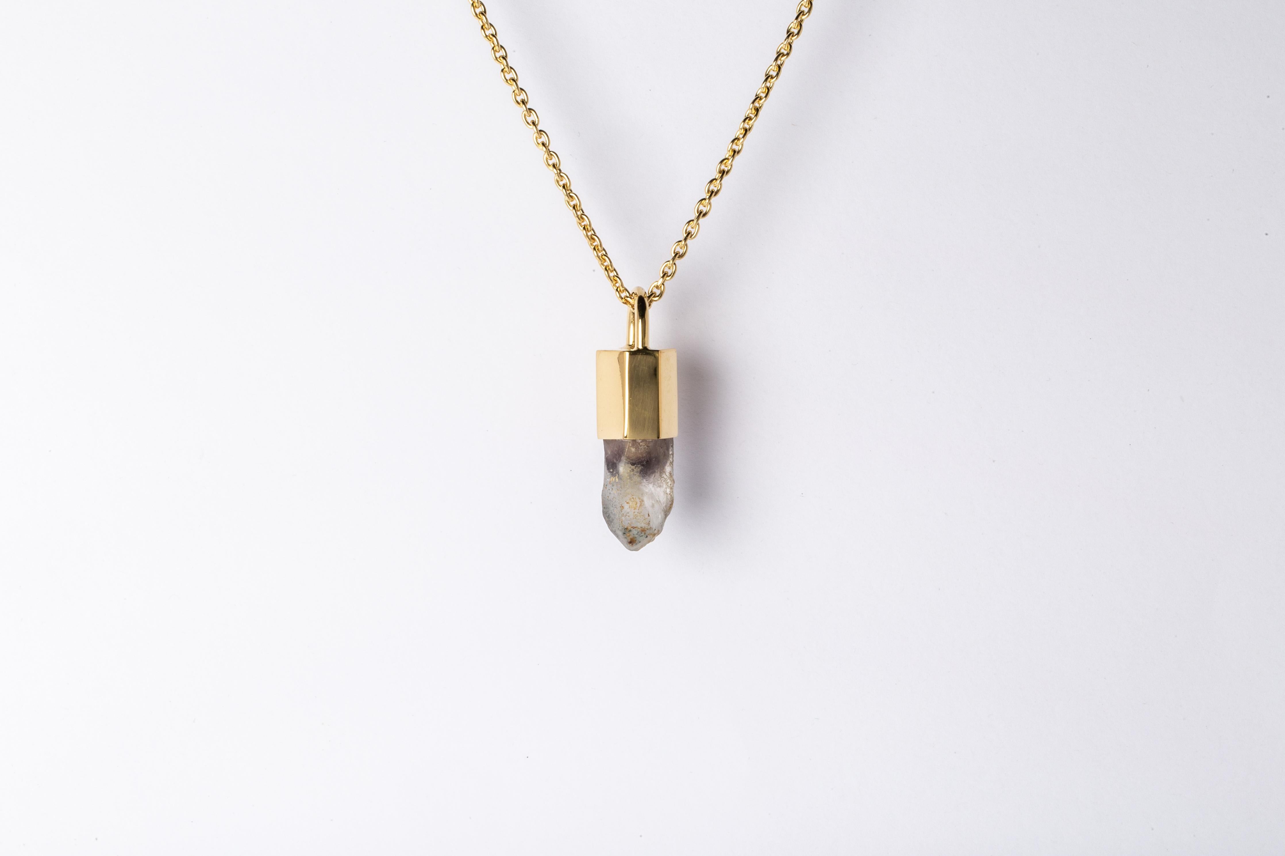 Pendant necklace in brass, sterling silver, and a rough of hematite quartz. Brass and sterling silver are substrate, polished and electroplated with 18k gold and then dipped into acid to create the subtly destroyed surface.
The Talisman series is an