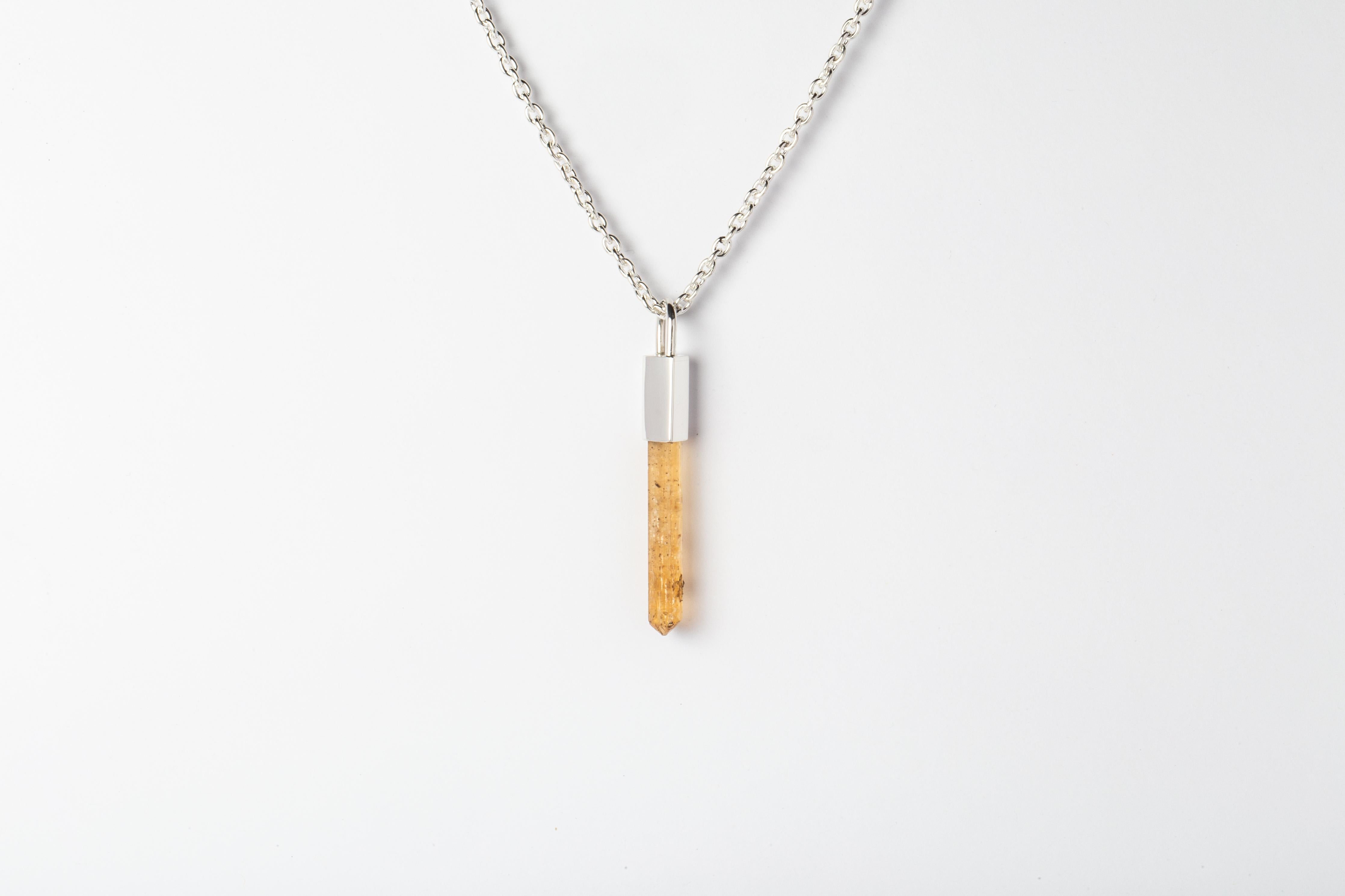 Necklace in polished sterling silver and a rough of imperial topaz. The Talisman series is an exploration into the power of natural crystals. The crystals used in these pieces are discovered through adventure and are hand selected. Each piece is