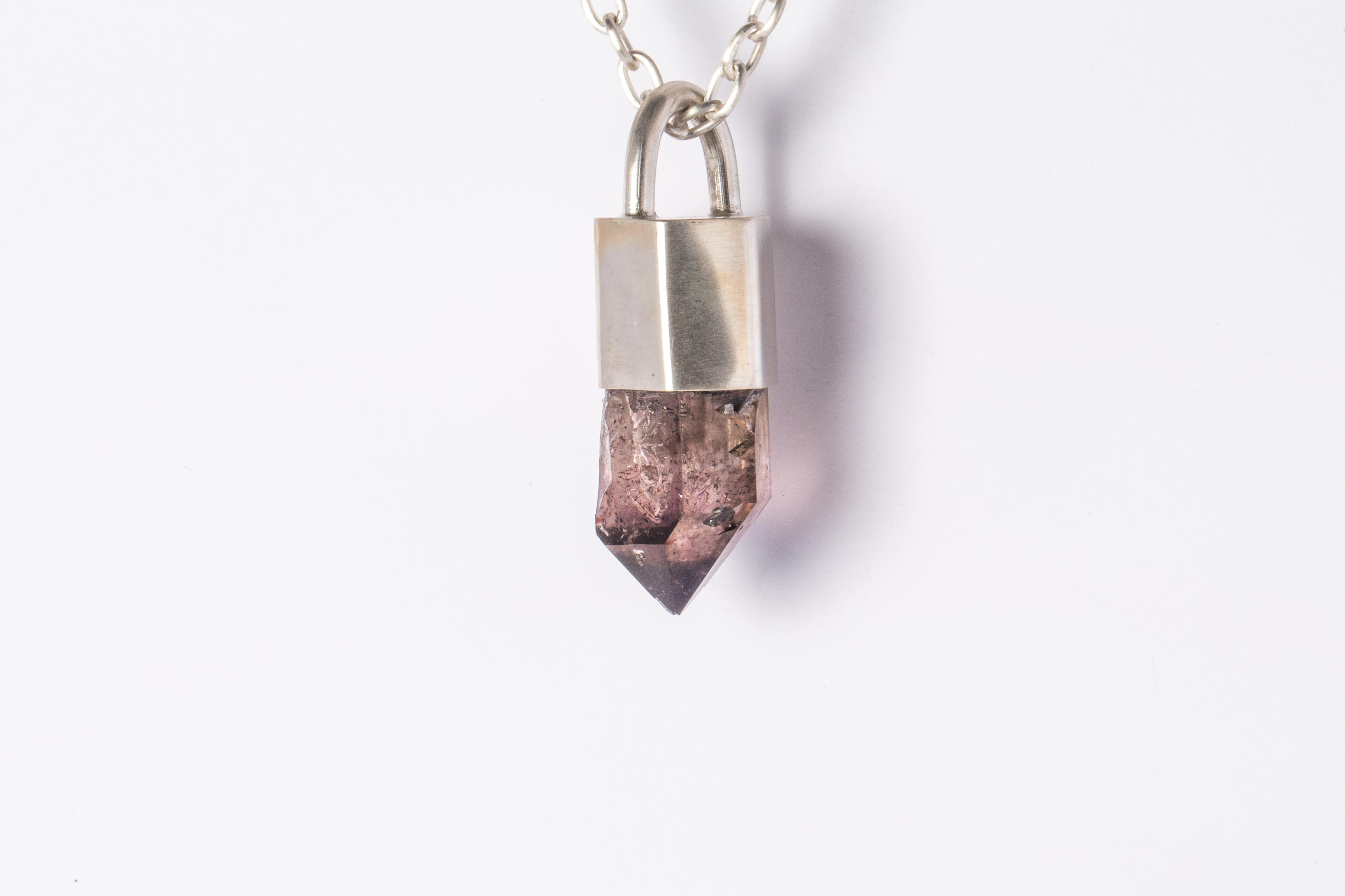 Pendant necklace in matte sterling silver and a slab of rough shangaan amethyst. It comes on a 75 cm sterling silver.
The Talisman series is an exploration into the power of natural crystals. Tools for Magic. The crystals used in these pieces are
