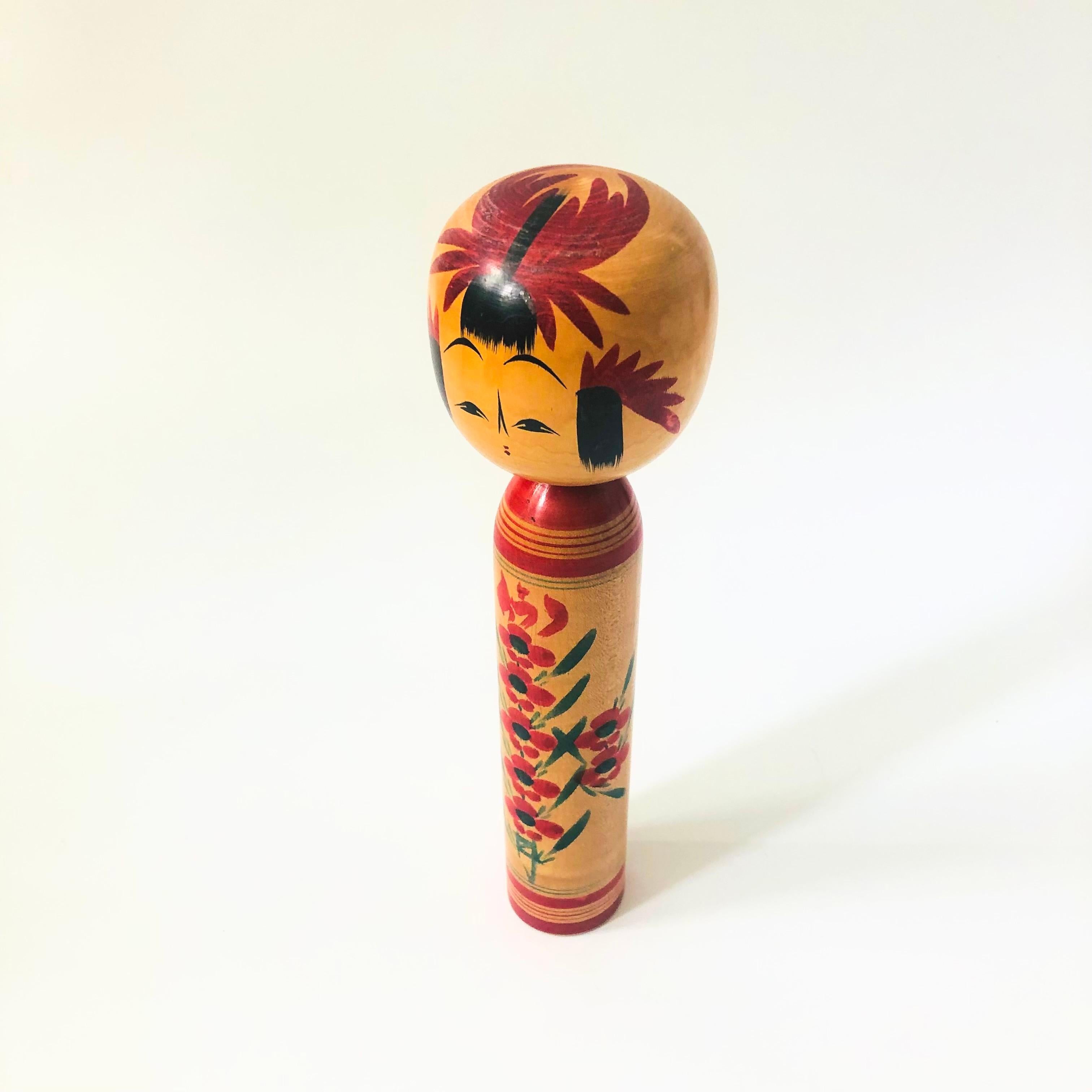 Un'alta bambola kokeshi giapponese vintage. Realizzato in legno con un delizioso disegno dipinto a mano di fiori rossi.

