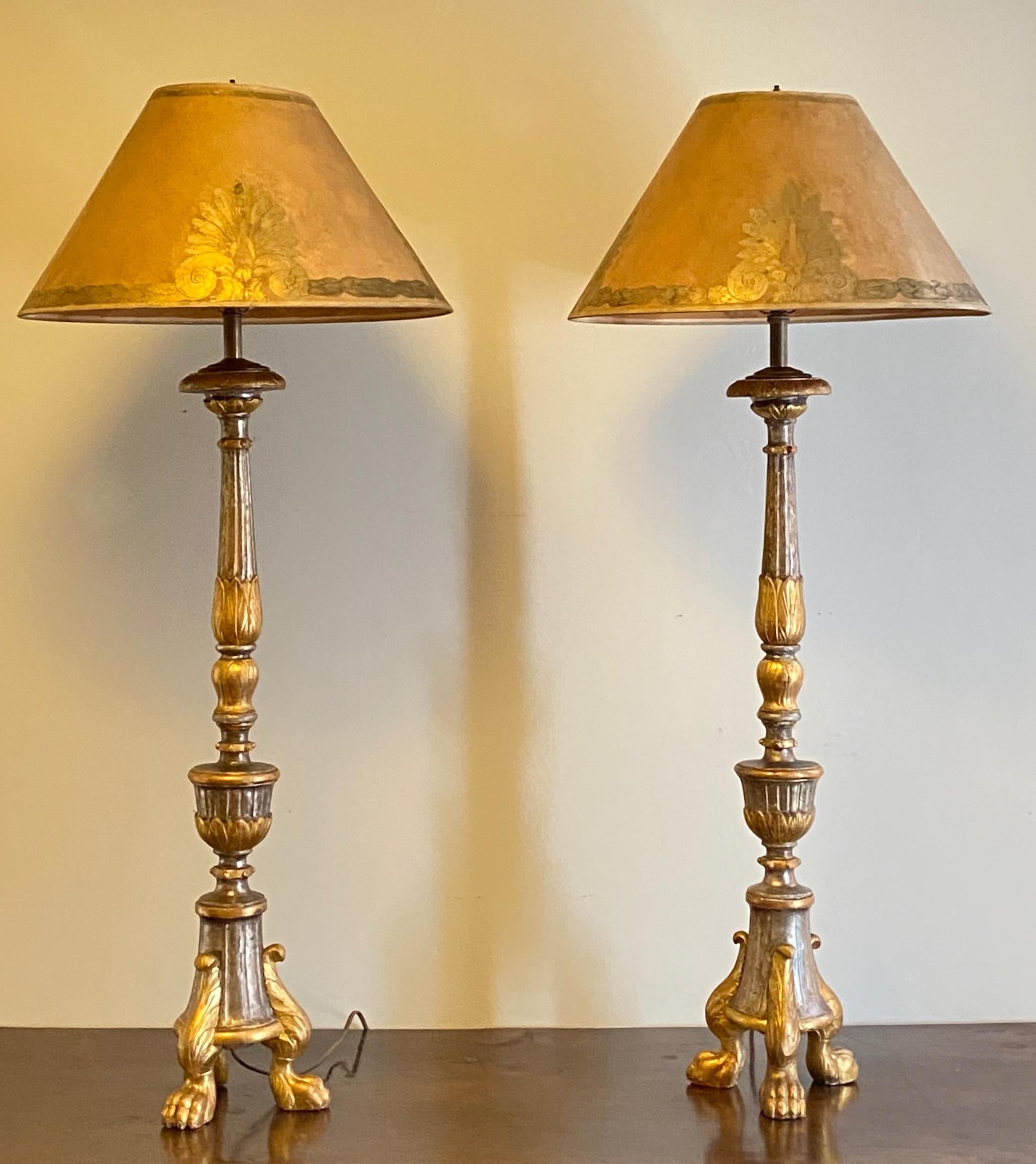 A pair of tall silver and gold gilt candle sticks professionally converted to table lamps.
Hand carved with beautifully contrasted silvered and gold gilt. These have weighted bases so they are stable and sturdy. In remarkable antique