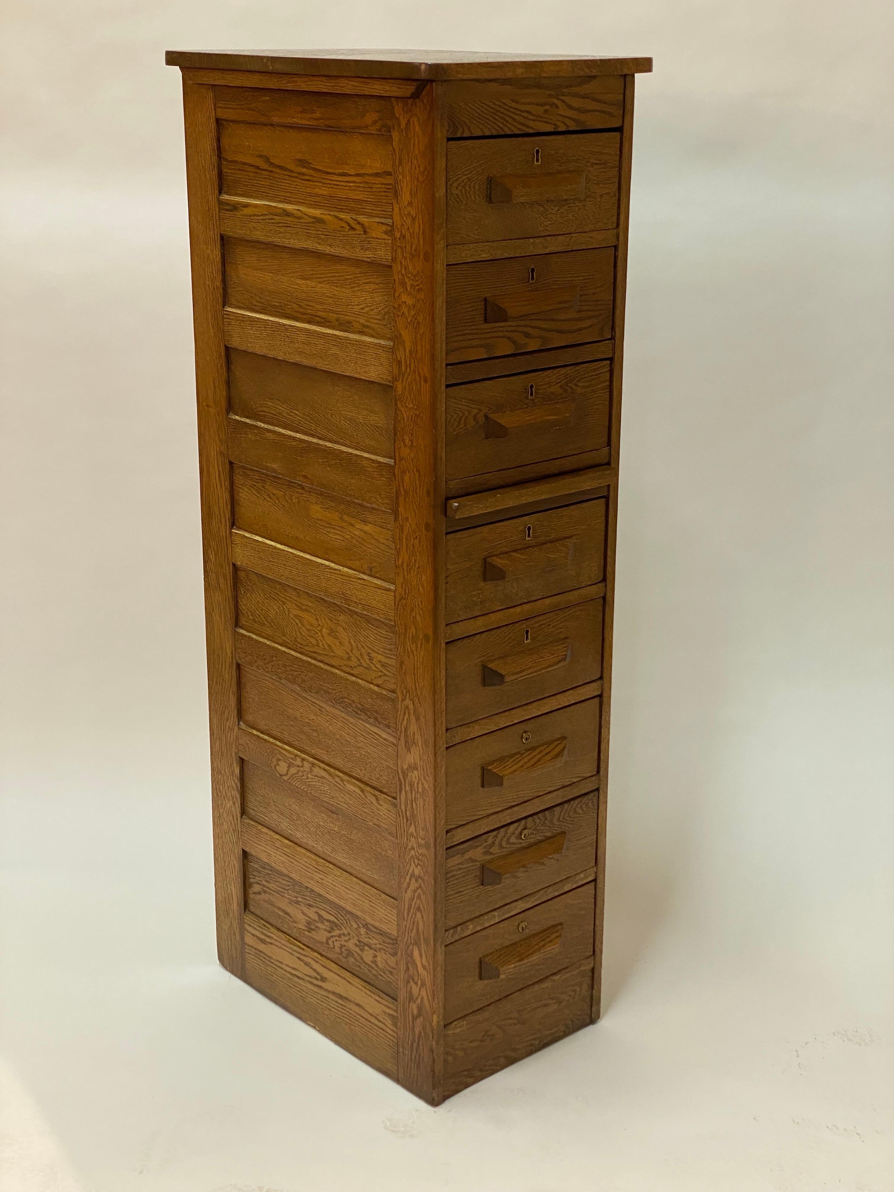 Tall solid golden oak eight drawer cabinet. Circa 1910-30. Featuring channeled drawer handles, bread board pull out shelf, doweled joinery and paneled sides. This piece is just a compliment to any small narrow space. The drawers originally came out