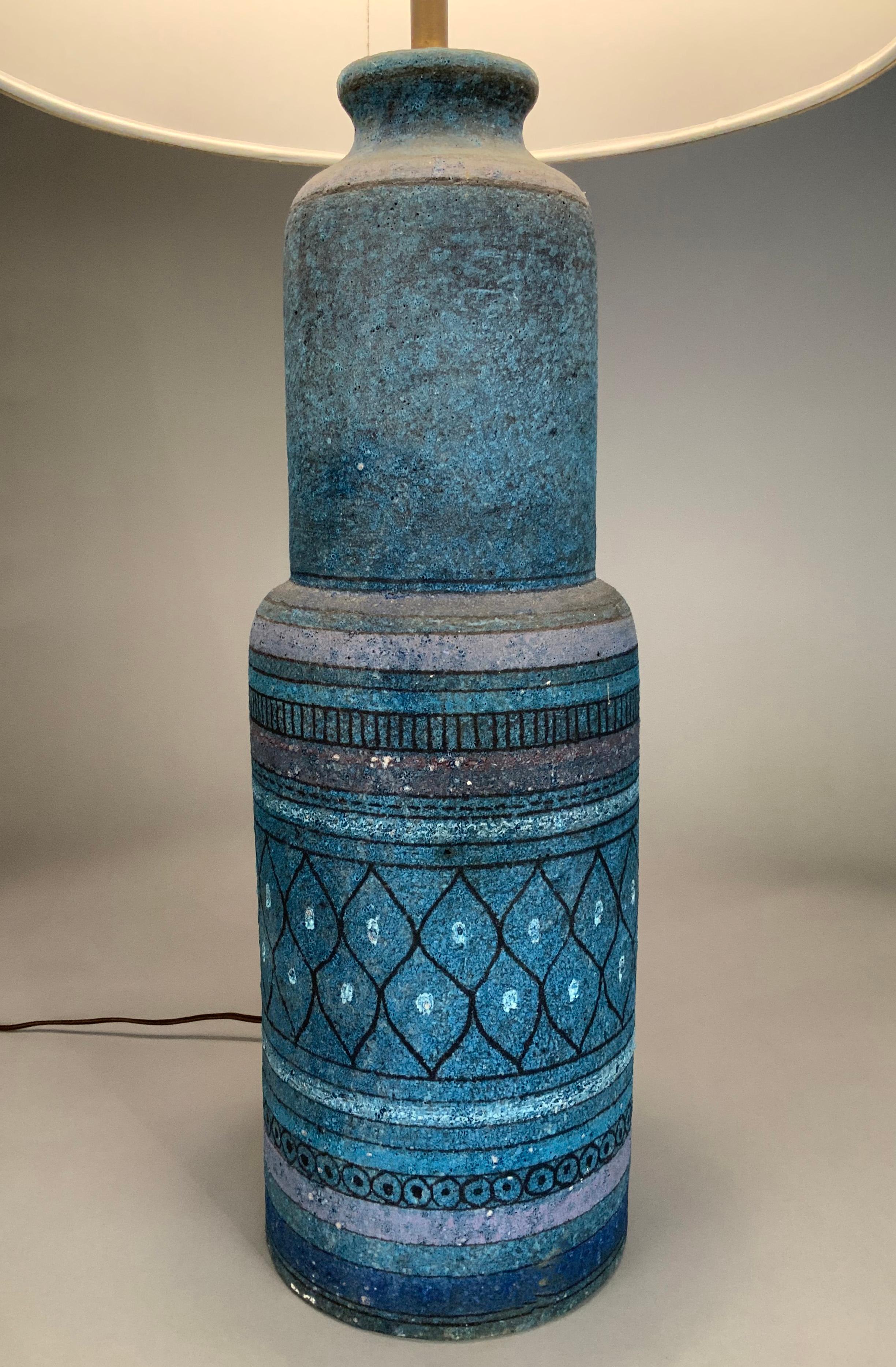 A tall and very handsome 1950's Italian ceramic lamp, with incised geometric patterns, and a matte finish glaze in shades of blue, and details in black. along with a new sand colored lampshade. base is marked Made in Italy.