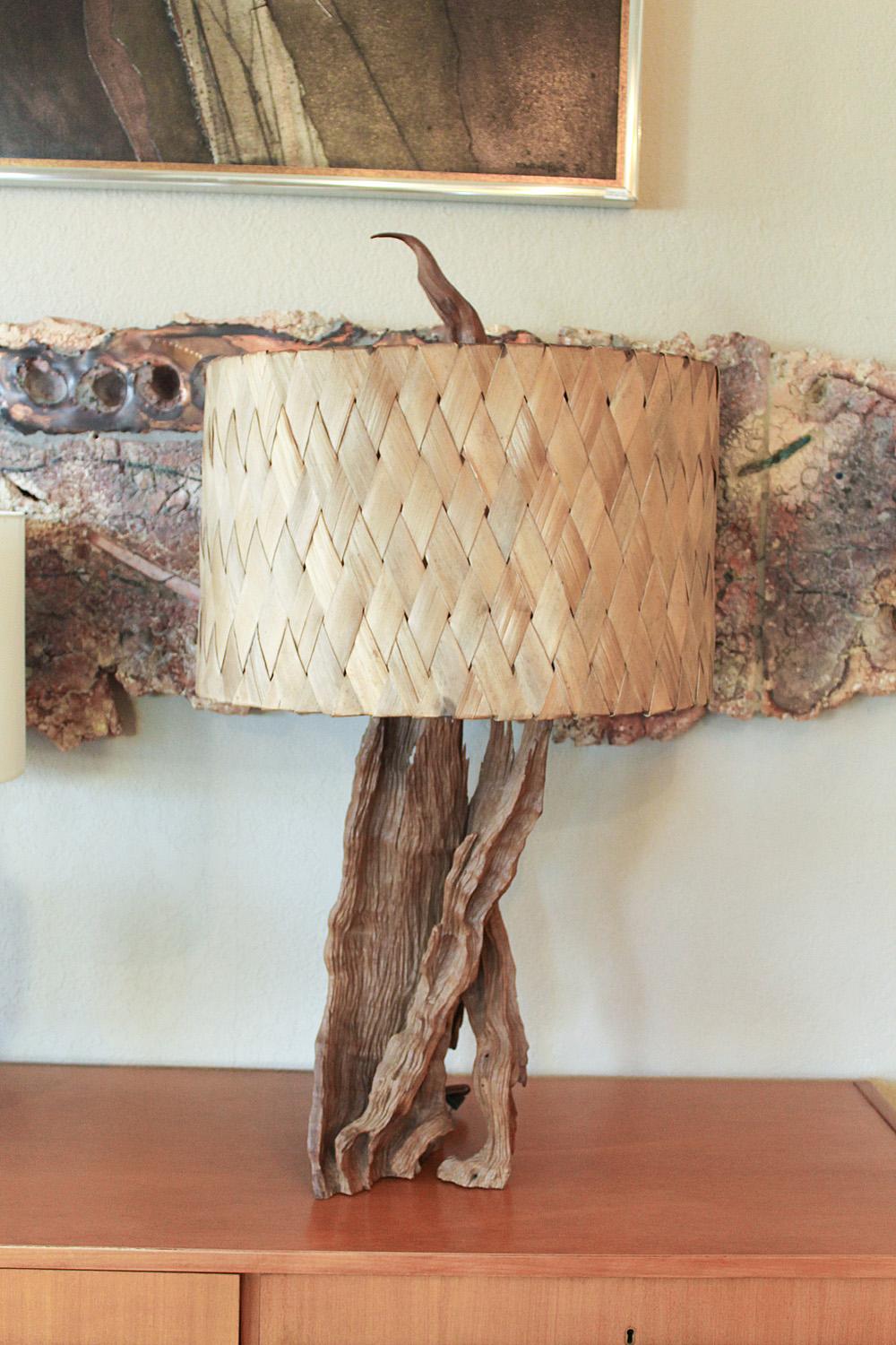 Softly weathered and wonderfully wild, this tall 1960s driftwood lamp with original finial and handwoven banana leaf shade is a sculptural addition to any seaside getaway. Oval shade measures 14