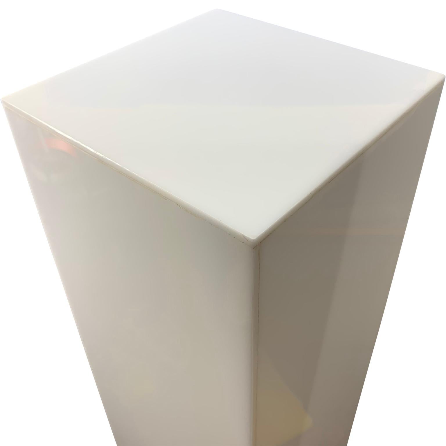 Tall modernist white Lucite or acrylic pedestal stand display column
Pedestal is electrified and lights up using a LED light bulb.