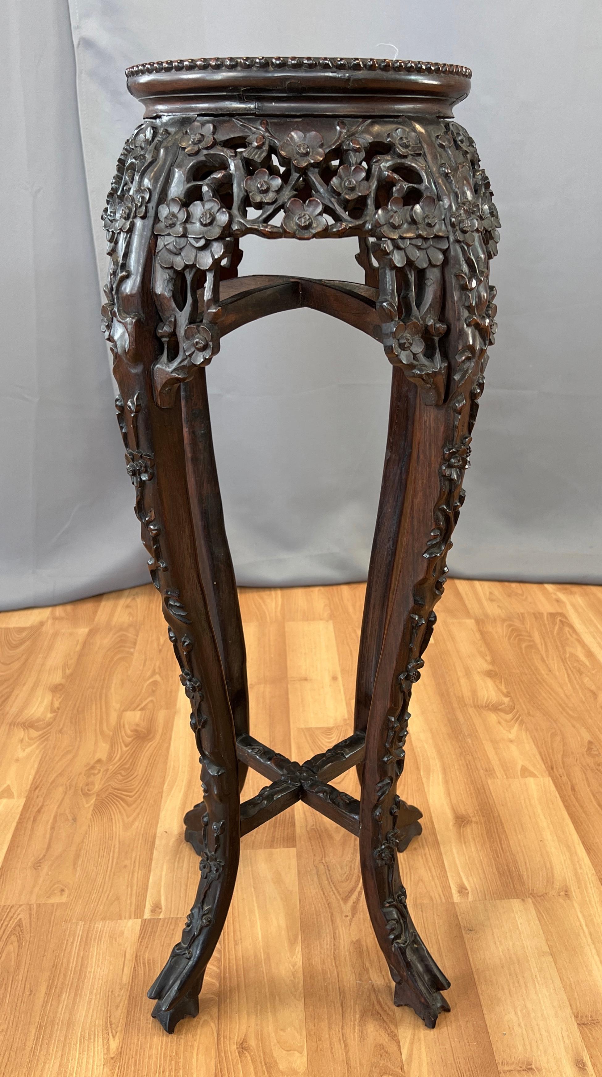 A stunning 19th century Chinese Rosewood and inset Marble plant stand.
Wonderful carved flower design on it's skirt, and on the outside of it's legs ending up at it's feet, that are also carved. 
Two cross braces, top set curves up like a dome,