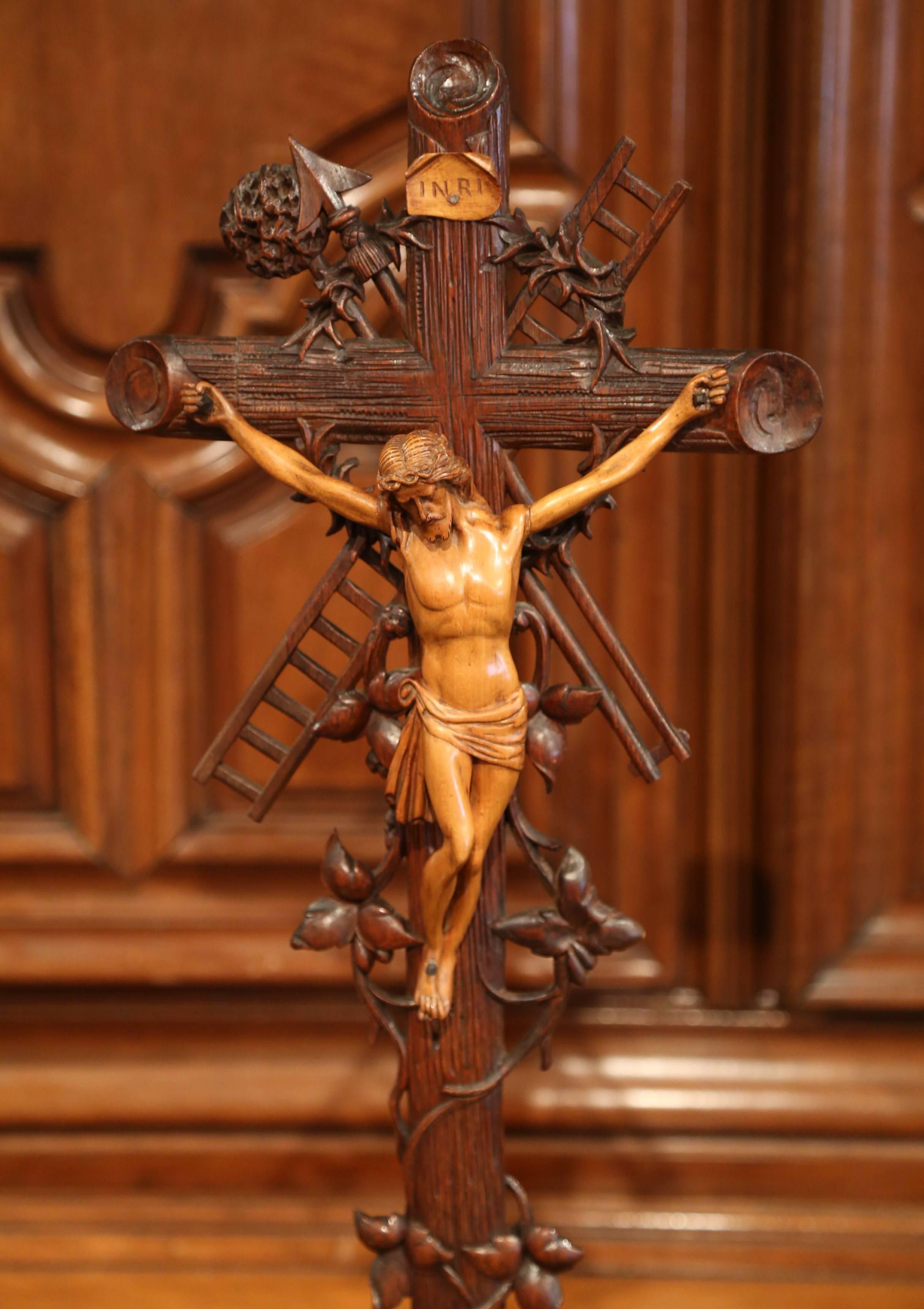 This elegant, antique cross was crafted in France, circa 1850. The intricate crucifix features the Lord nailed on the cross with some of the most interesting attributes related to His crucifixion. The carved motifs include the thorn crown, the