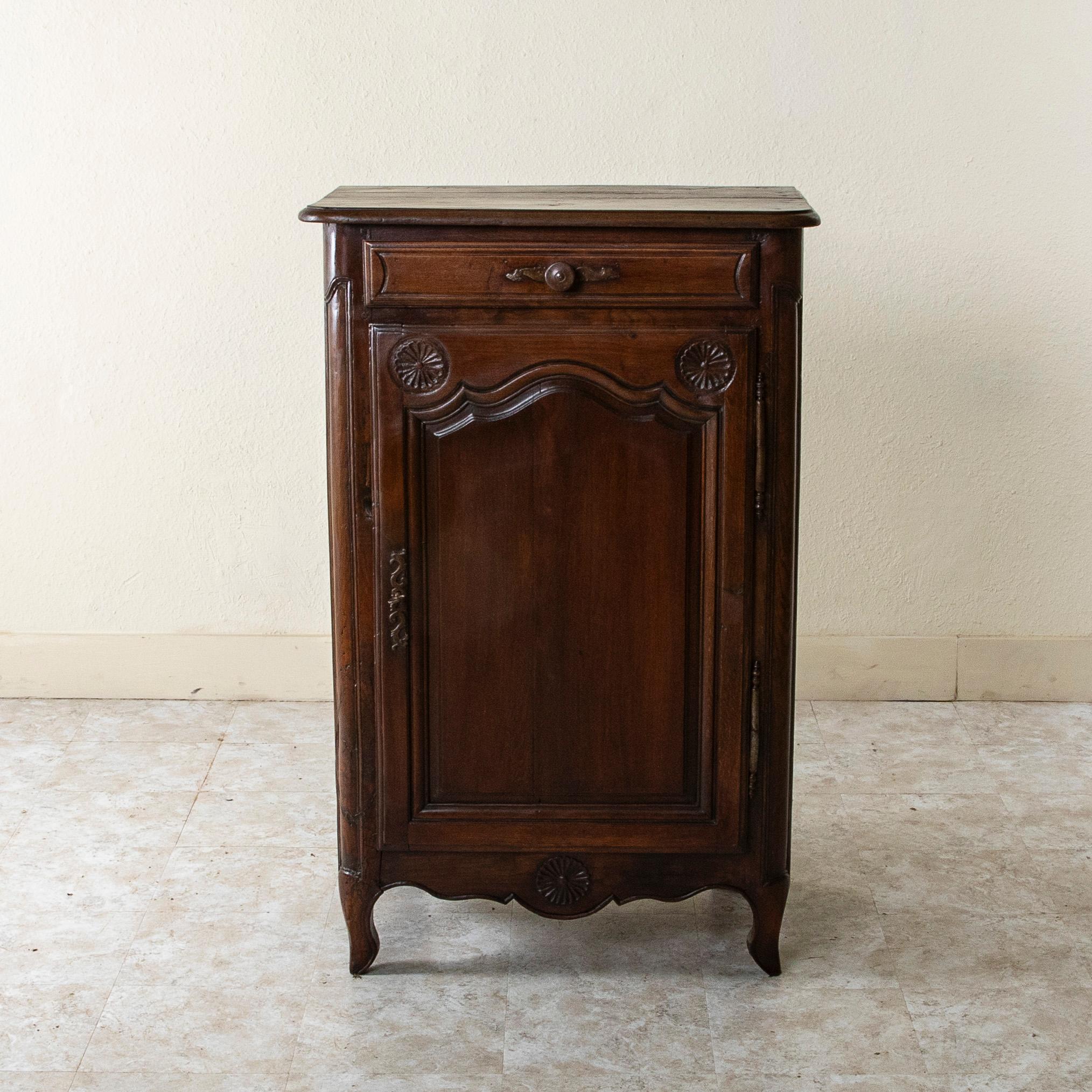 Standing at 37 inches in height, this tall nineteenth century oak jam cabinet from the region of Normandy, France, features hand carved regional details of rosettes on its facade. A single drawer below the beveled top opens with an iron drawer pull.