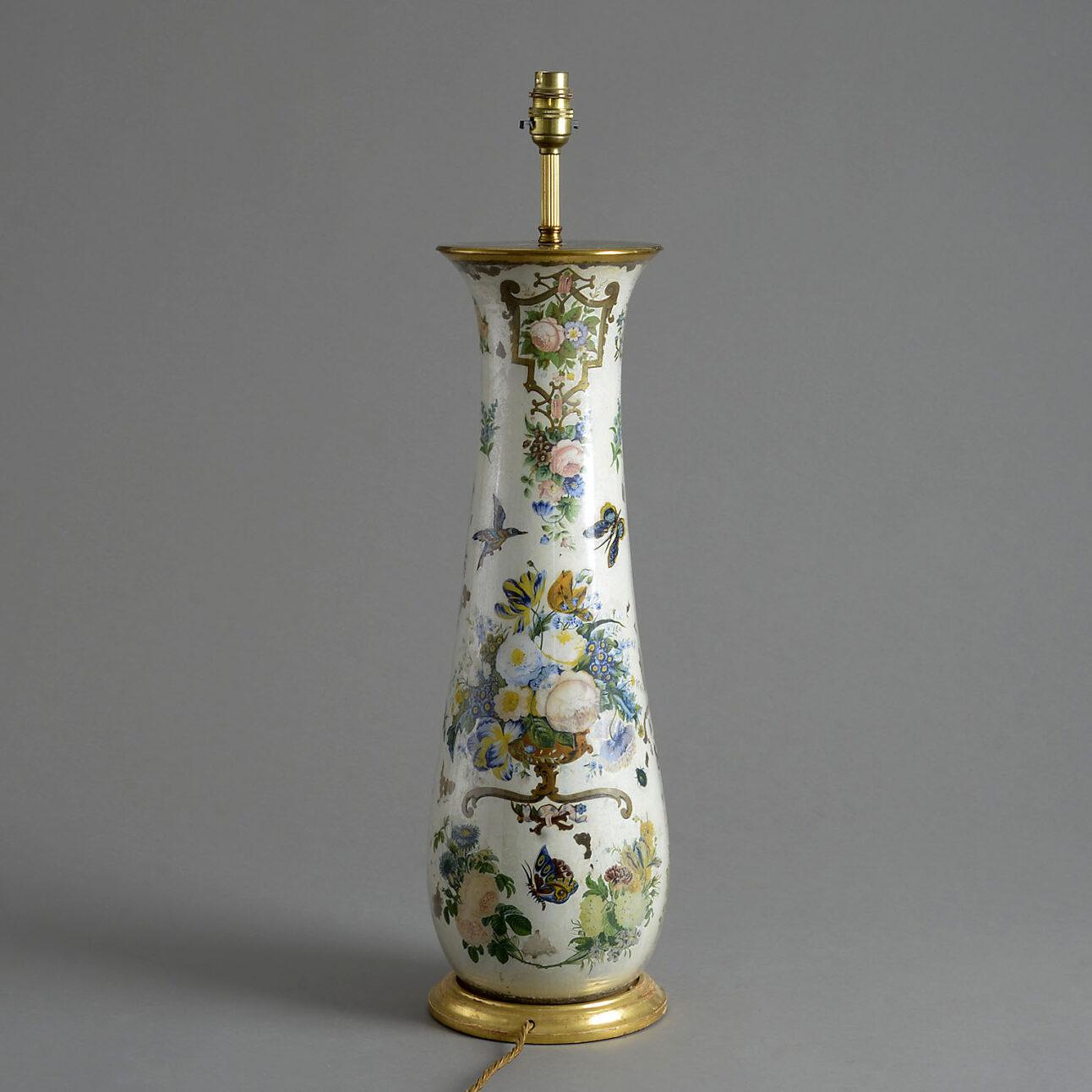 A tall 19th century Victorian vase of elongated form decorated with flowers and birds upon a cream coloured ground. Set upon a turned giltwood base and wired as a lamp with silk flex.

Wired to UK Standards. This lamp can be re-wired to any