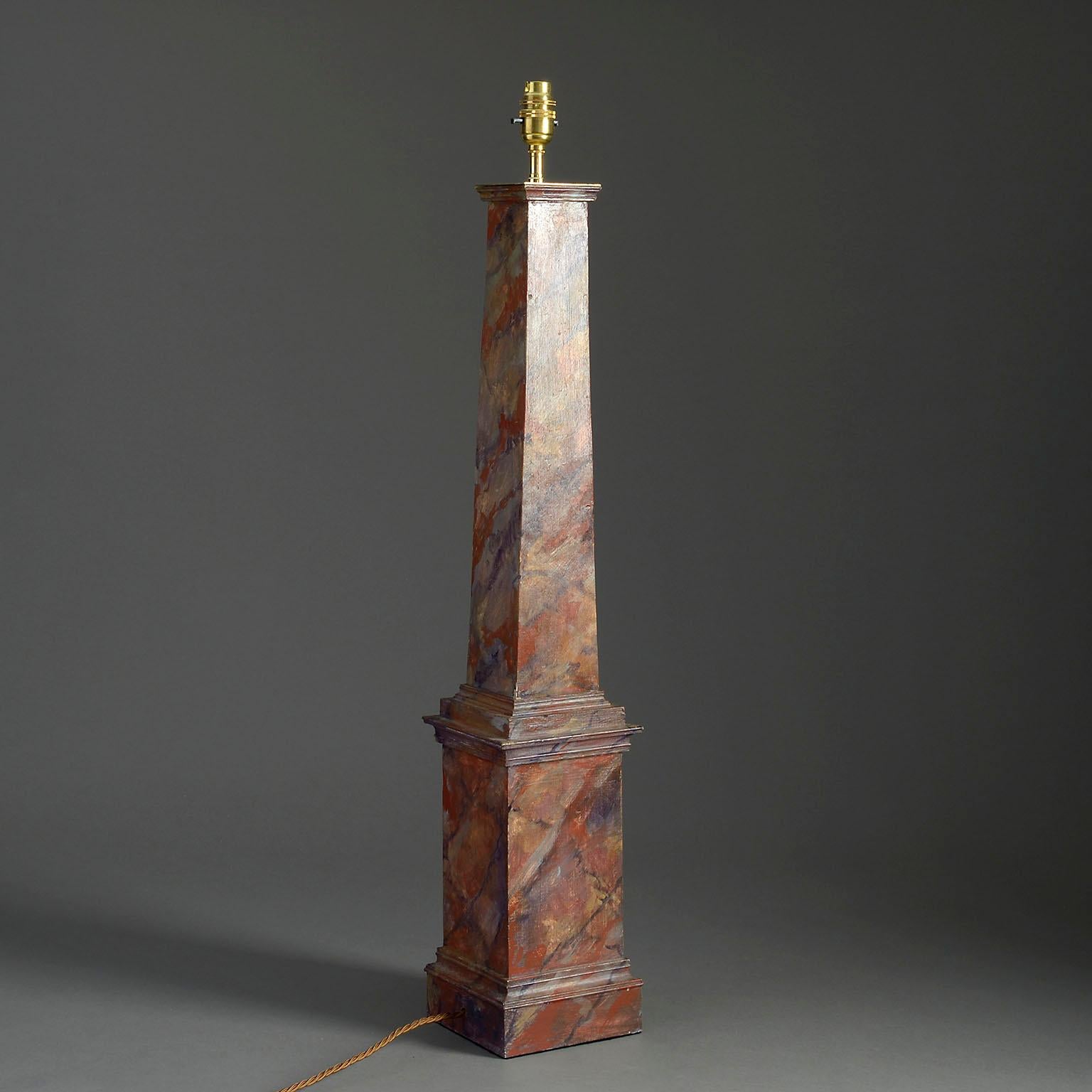 A mid-twentieth century table lamp in the form of an obelisk, the surfaces painted to simulate marble.

Dimensions refer to painted wooden parts only.

Wired to UK standards. This lamp can be rewired to all international specifications inclusive