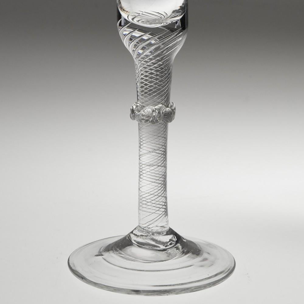 Heading : Air twist stem Georgian wine glass with vermicular collar
Period : George II - c1750
Origin : England
Colour : Clear, good pucella marks
Bowl : Bell
Stem : Multi spiral air twist with vermicular collar
Foot : Conical
Pontil : Snapped
Glass