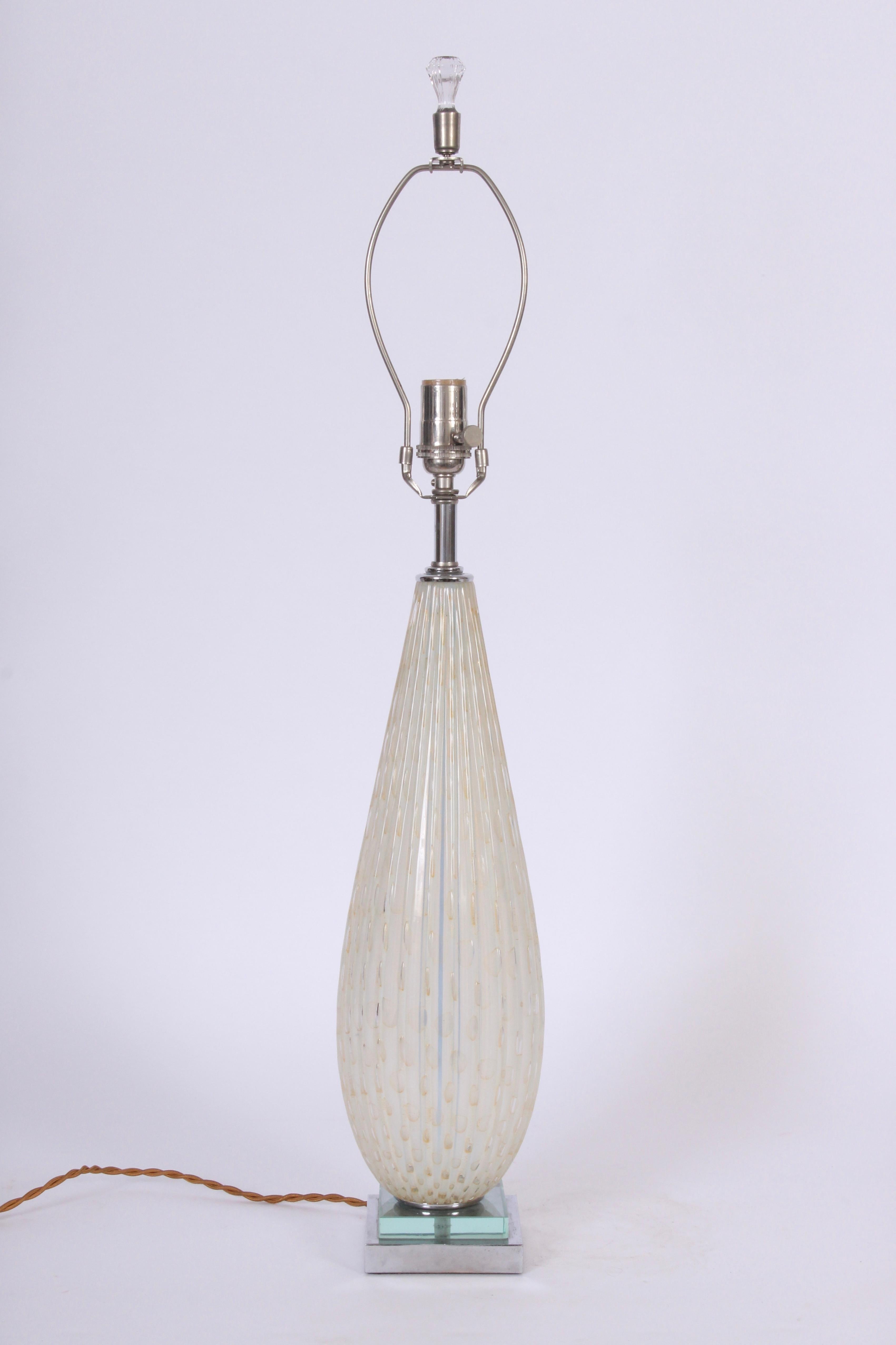 Monumental Alfredo Barbini Opaline Murano Glass Table Lamp with Gold rimmed bubbles, 1950's. Small footprint.  Featuring a slender, hand blown, translucent White tear drop form with controlled oval bubbles on a stacked square Chrome and Crystal base