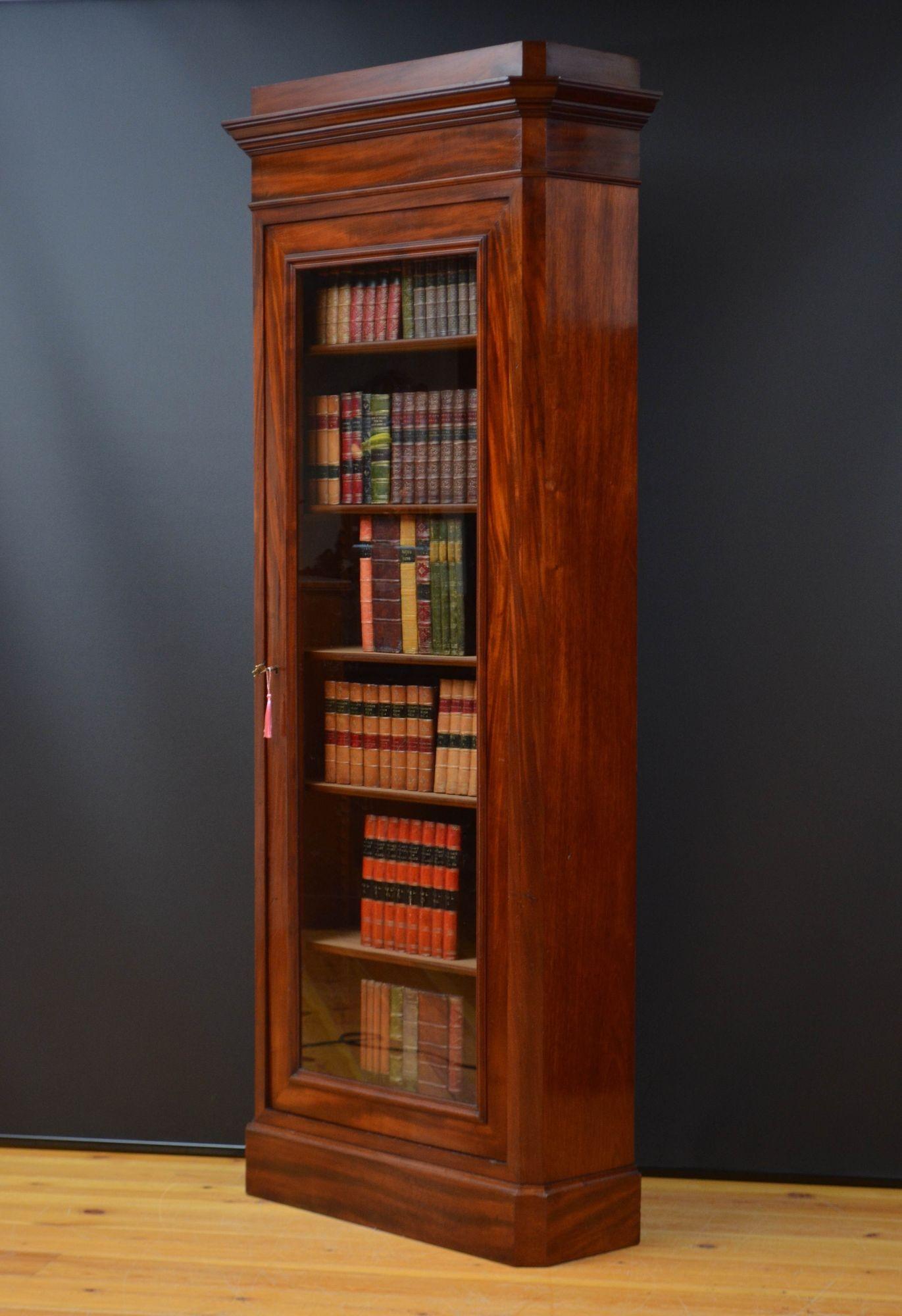 Sn5598 Alta e sottile libreria in mogano del XIX secolo, con cornice a cavetto sopra un'anta a vetro singolo dotata di serratura originale funzionante e di una chiave e che racchiude cinque ripiani regolabili in altezza, il tutto affiancato da