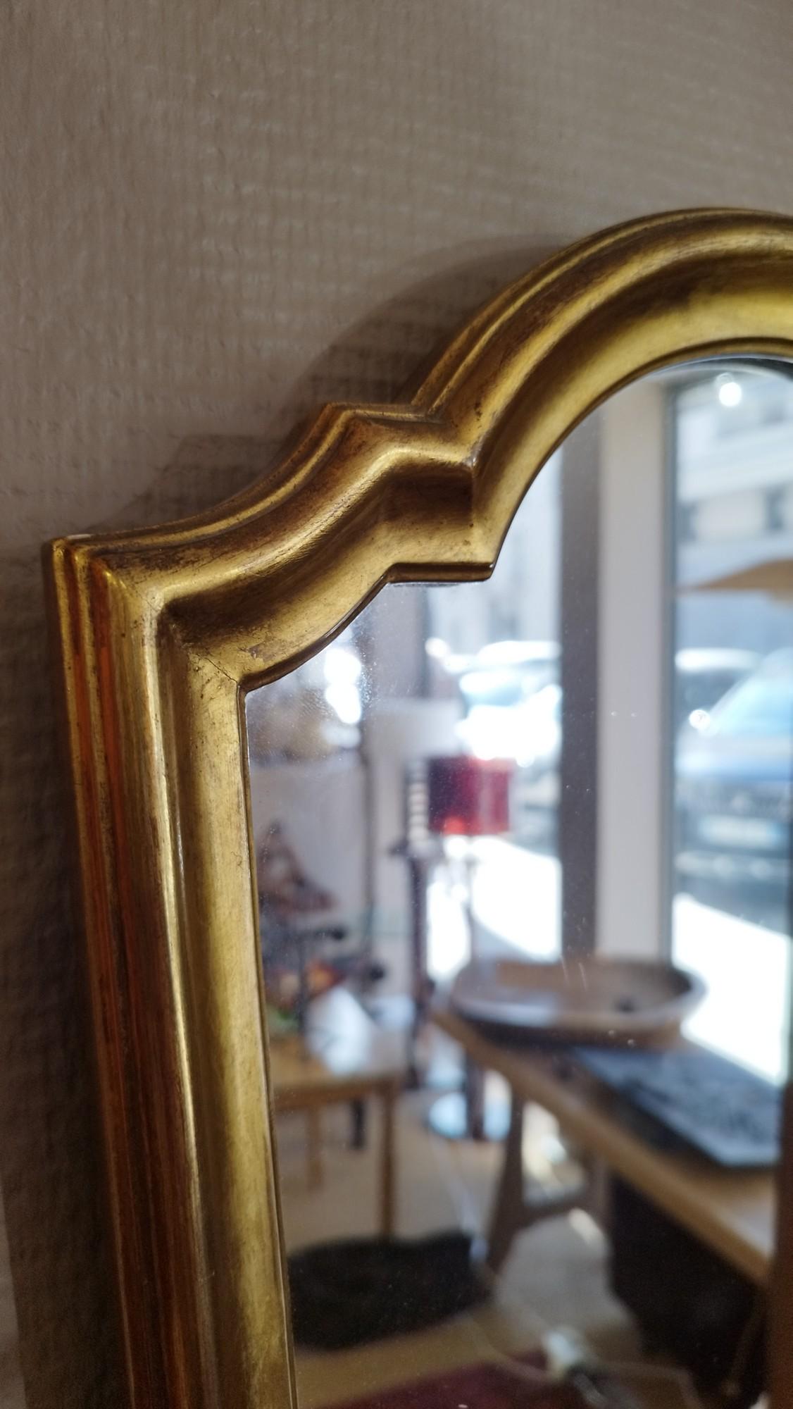 Joli miroir en bois doré, haut et fin, datant des années 70. 