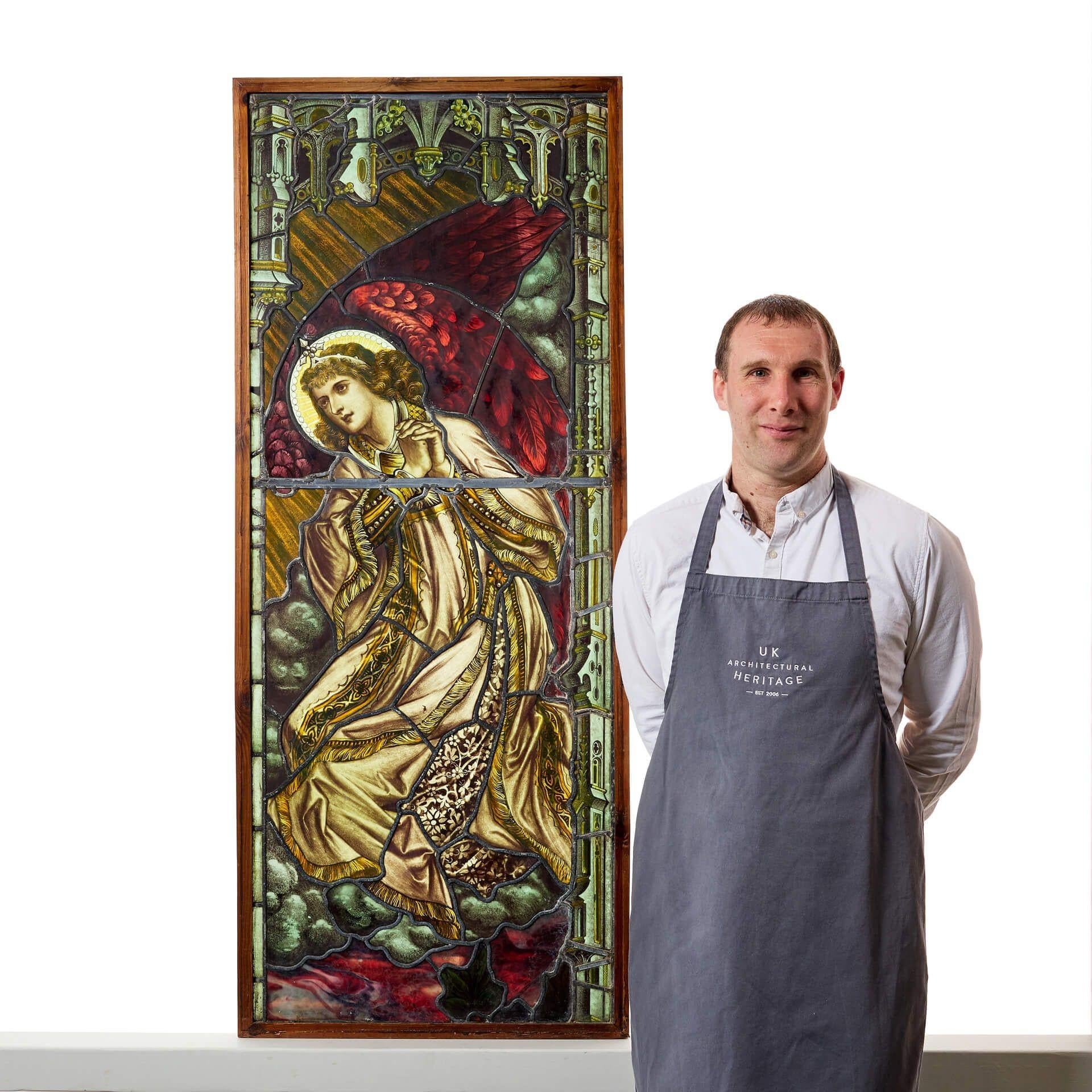 A tall antique late 19th century figural panel depicting an angel with her hands clasped.  

Dating to circa 1890, this stained glass incorporates both Victorian and Arts and Crafts styles creating in vibrant colours. 

With its vibrant colours,