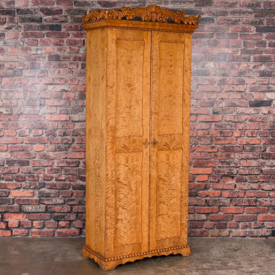 Simple yet elegant, the flame birch glows on this tall and narrow Swedish cabinet. The cabinet offers a number of versatile storage options with it's narrow width and multiple fixed shelves inside. An interesting feature is the removable decorative