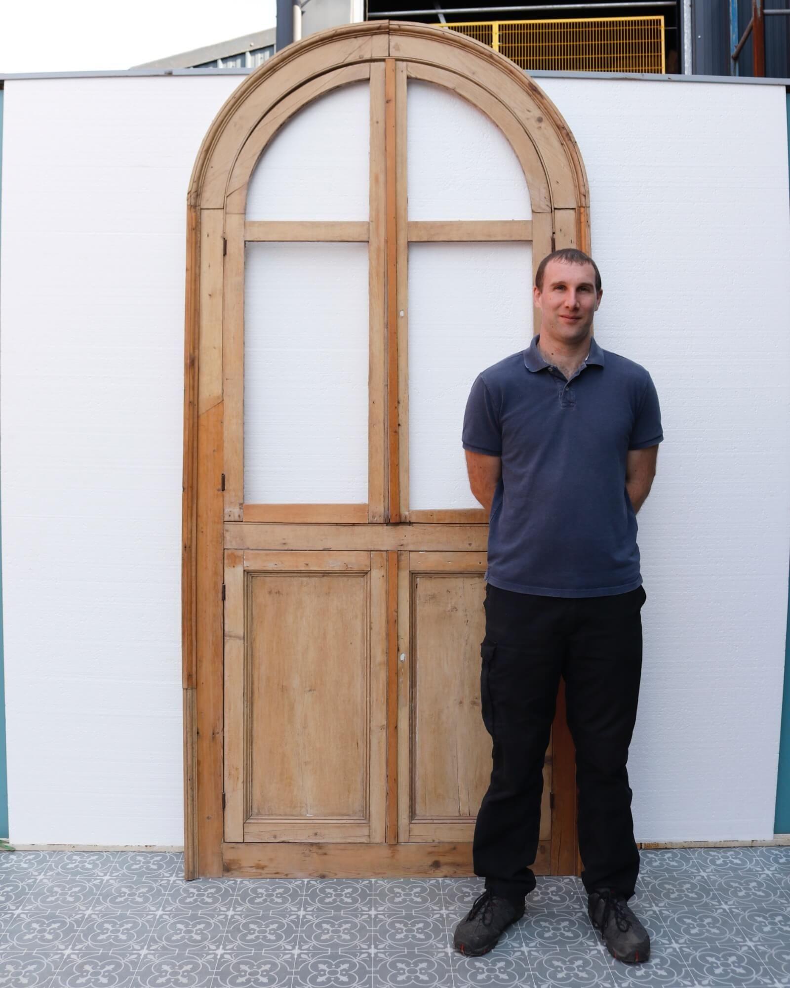 Una puerta alta de armario antiguo sin esmaltar, diseñada para colocarse en una alcoba interior arqueada.

Esta puerta de pino decapado se compone de 4 armarios practicables: dos puertas de arco sin acristalar en la mitad superior, y dos puertas de