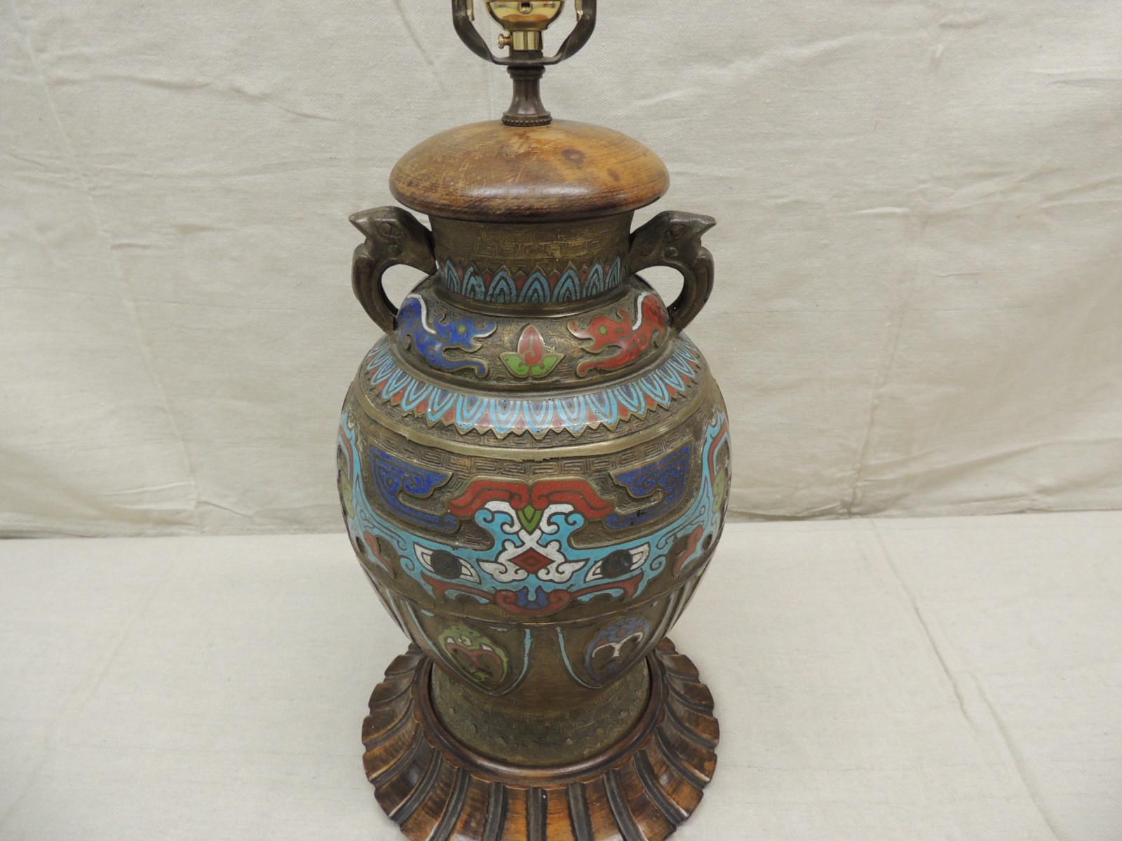 Antique cloisonné table lamp with enamel in shades of turquoise, red, white, green and purple. Cloisonné lamp base rests on a hand carved wood round base with a wood topper. Lamp offered with a harp no shade. Newly rewired with a three-way light
